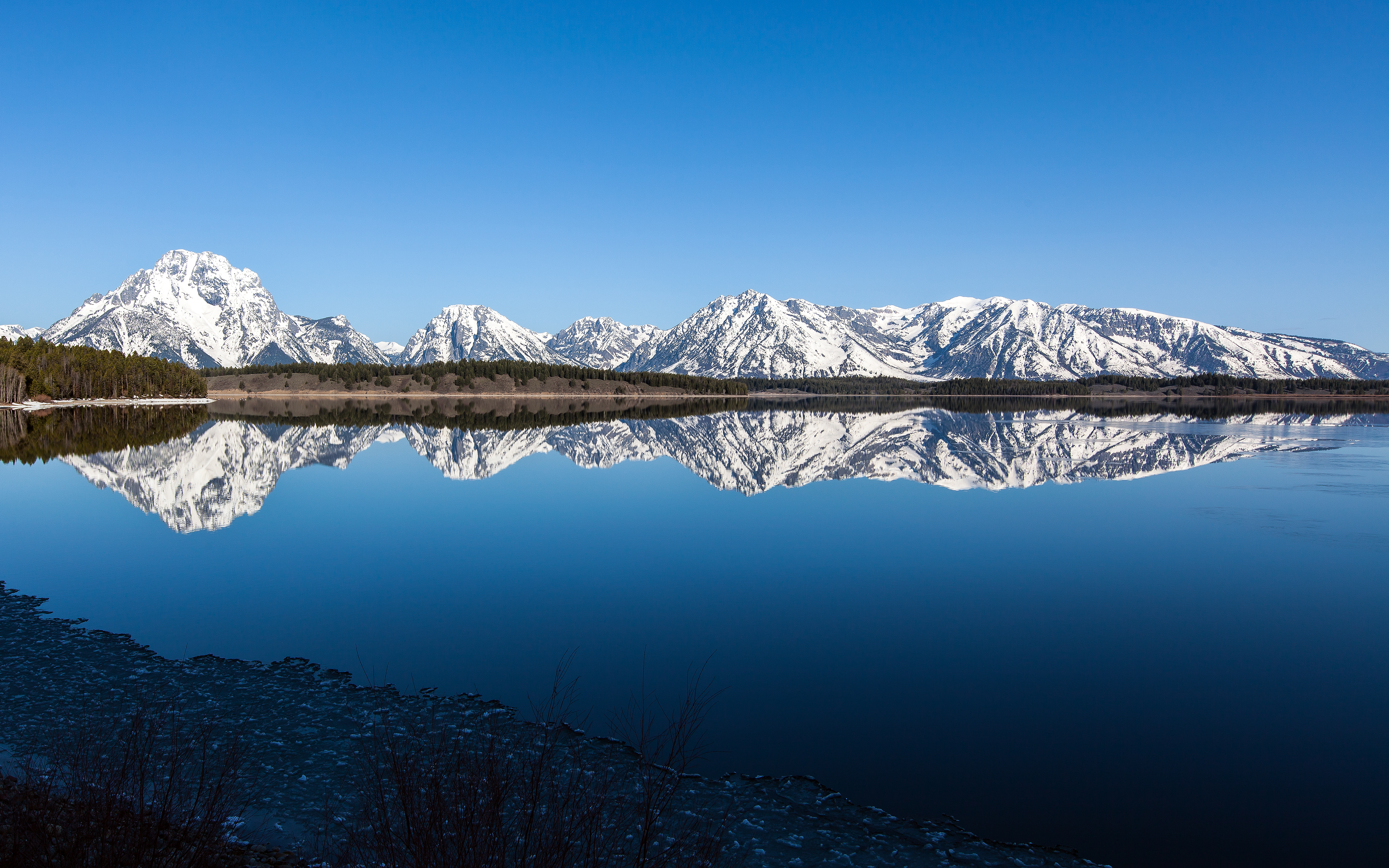 Snow-capped Teton Range reflected in a calm lake HD Wallpaper