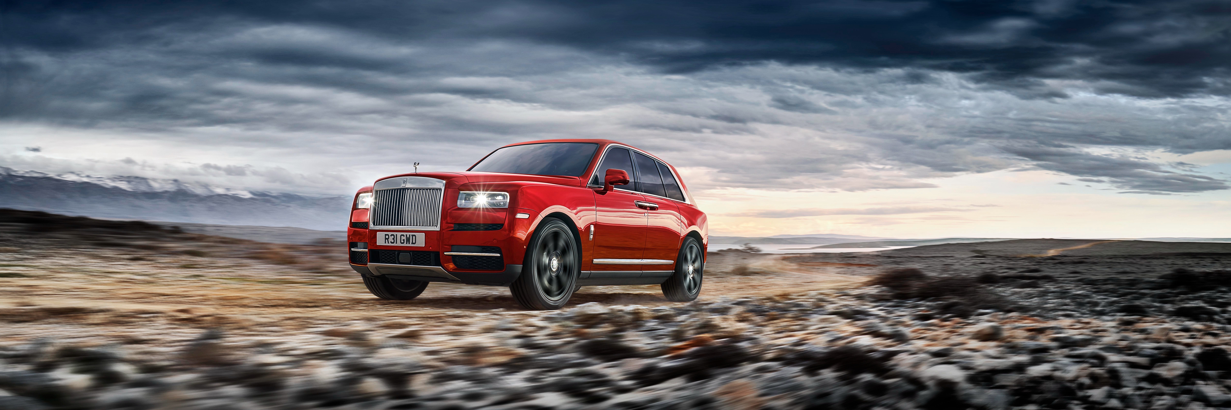 Red Rolls-Royce Cullinan driving on a rocky terrain HD Wallpaper