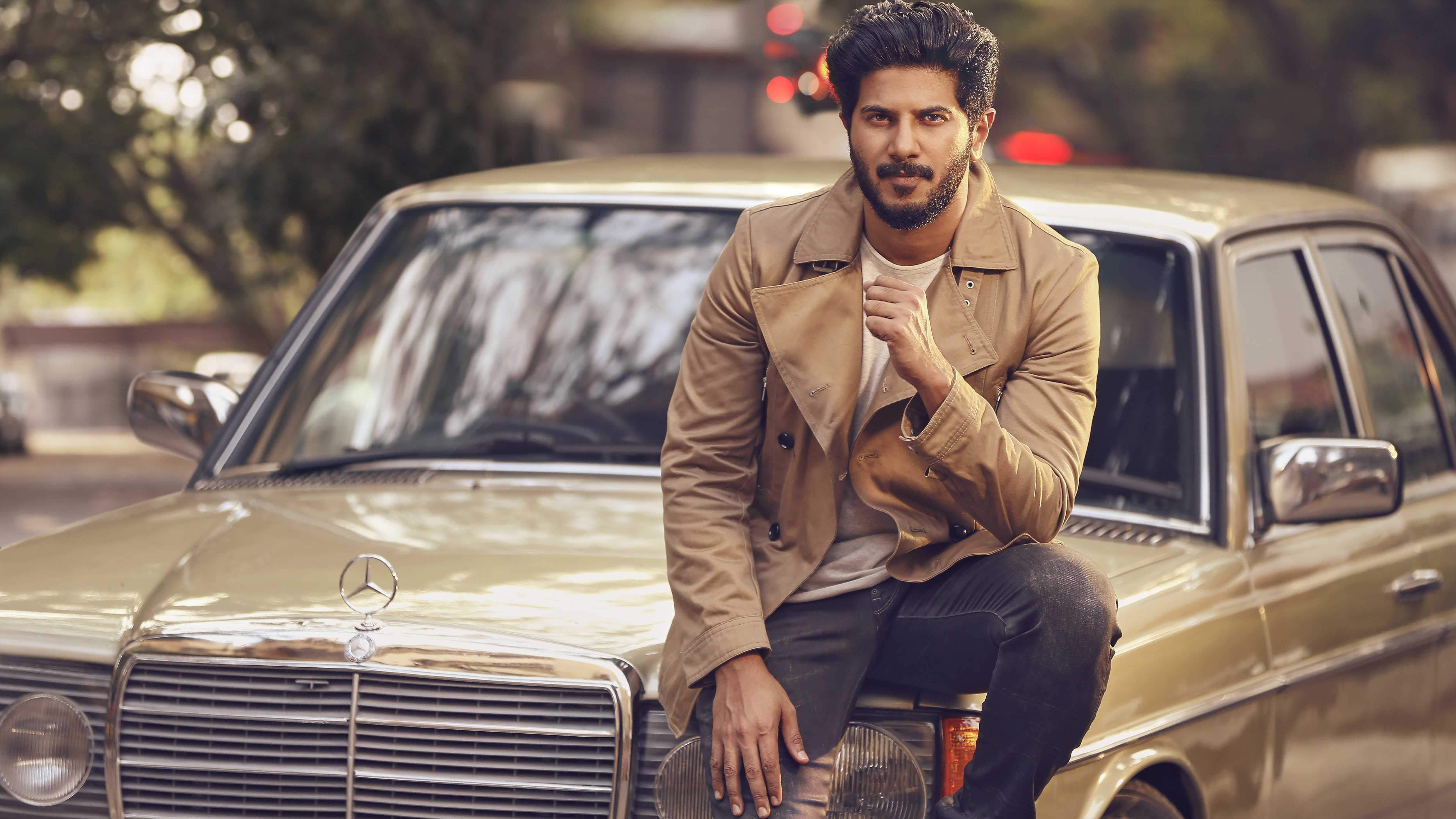 Dulquer Salmaan sitting on a vintage Mercedes-Benz HD Wallpaper