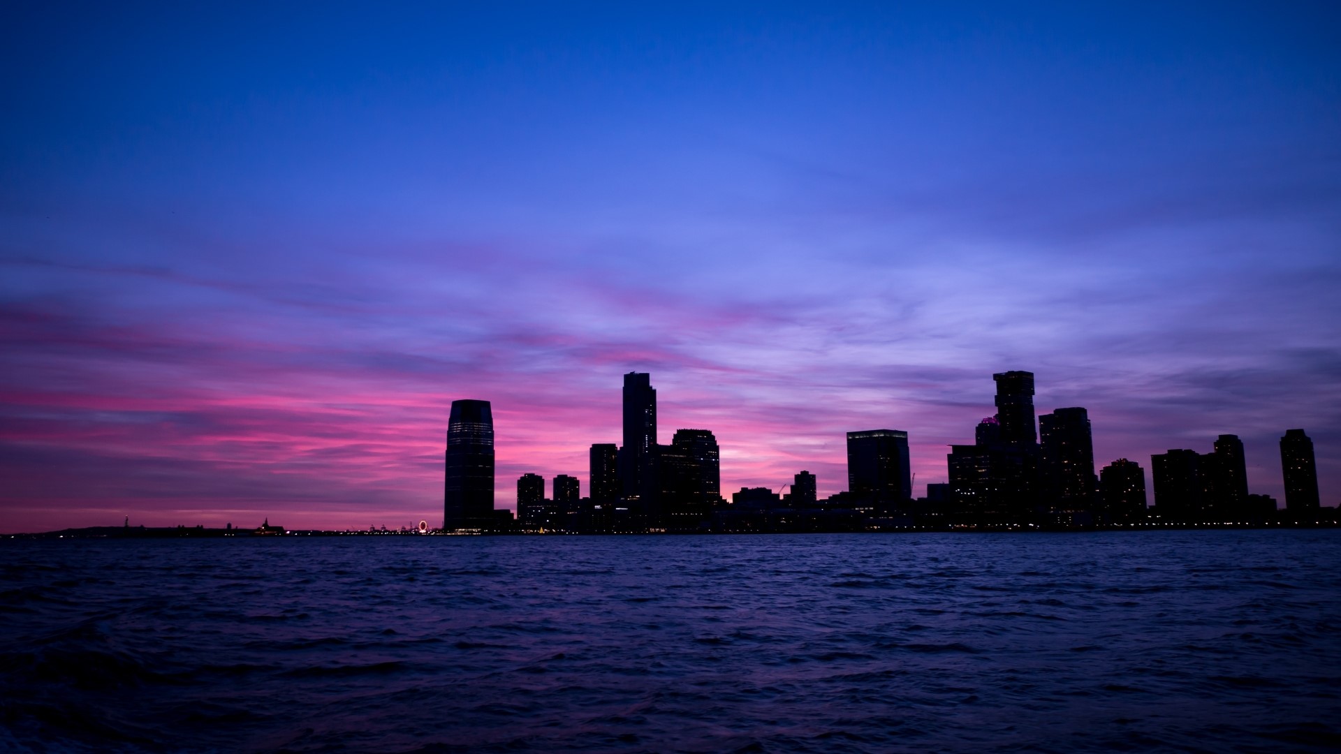 New York City skyline at sunset over water HD Wallpaper