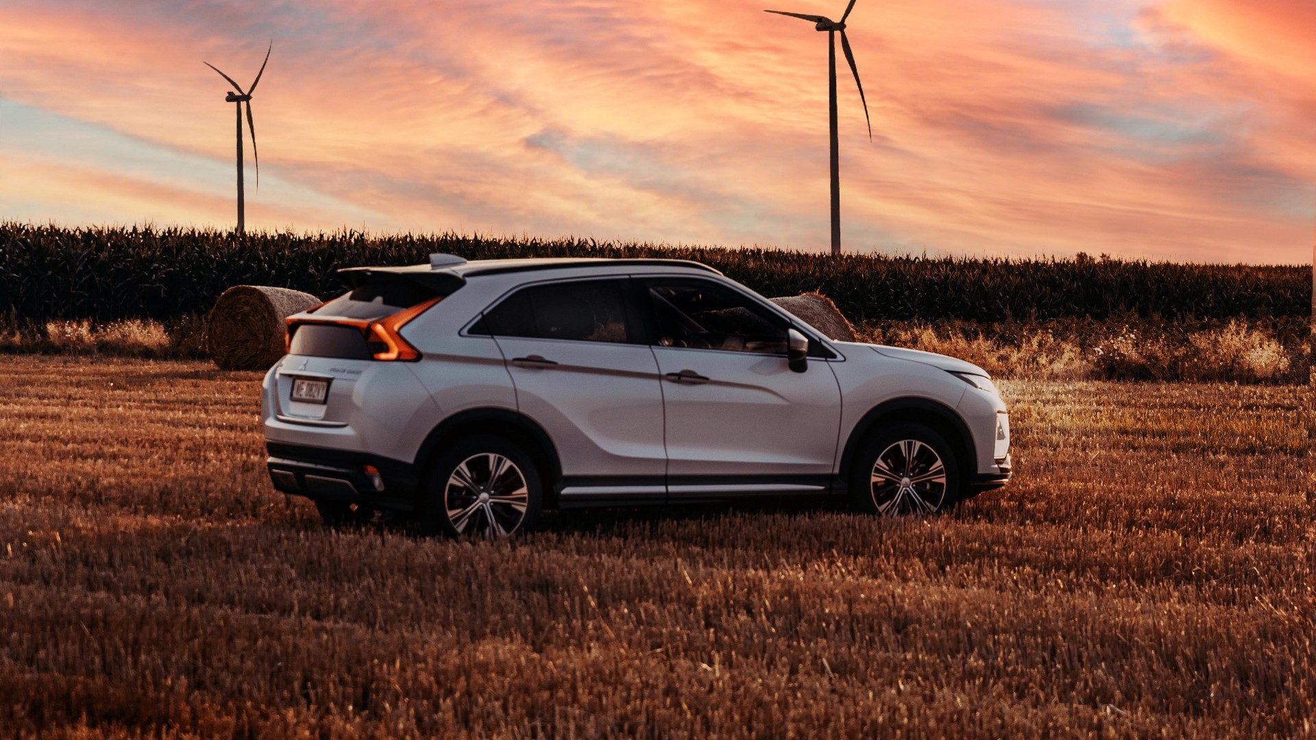 Mitsubishi Eclipse Cross in a field with wind turbines HD Wallpaper