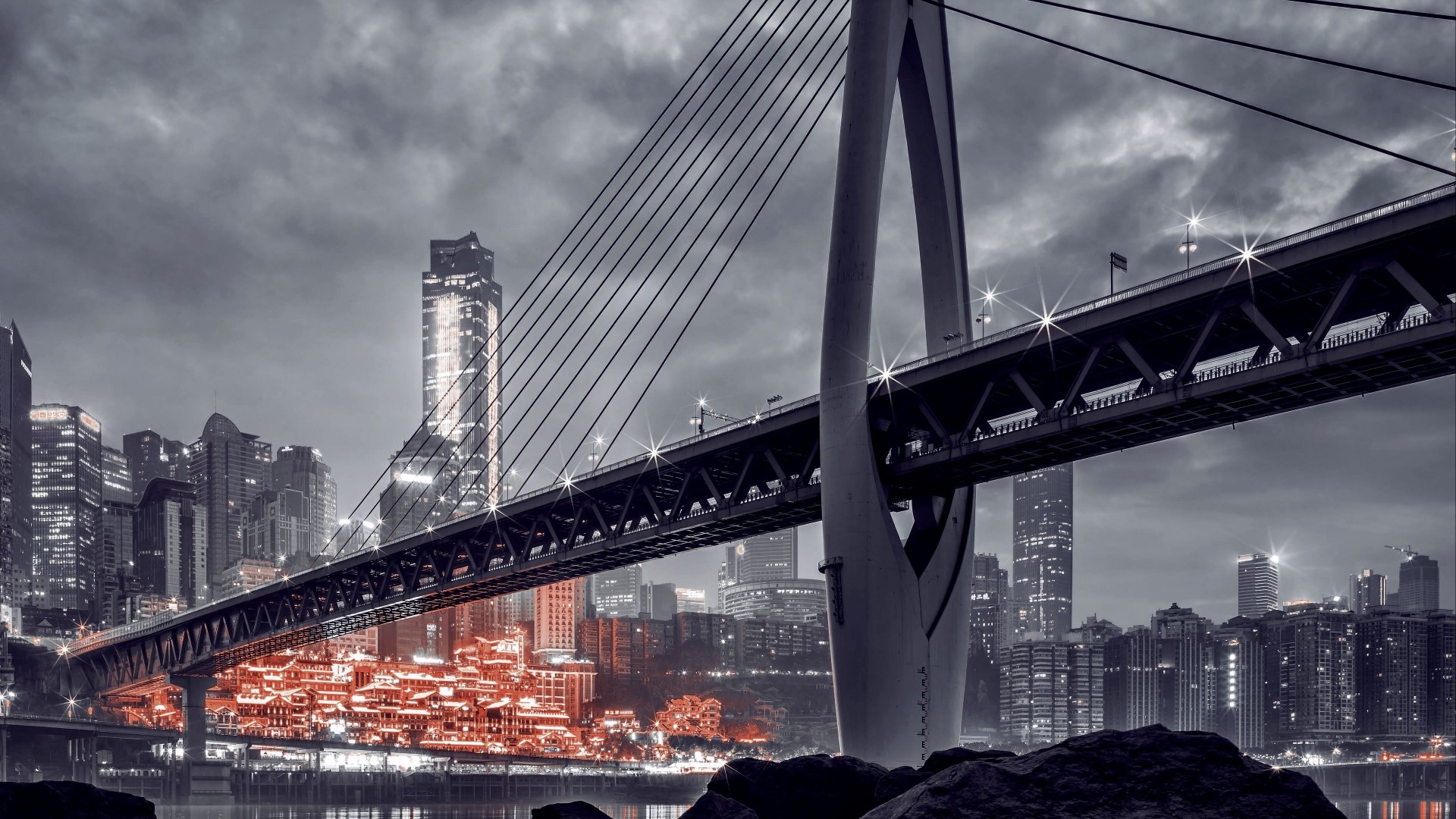 Bridge over a city with illuminated buildings HD Wallpaper