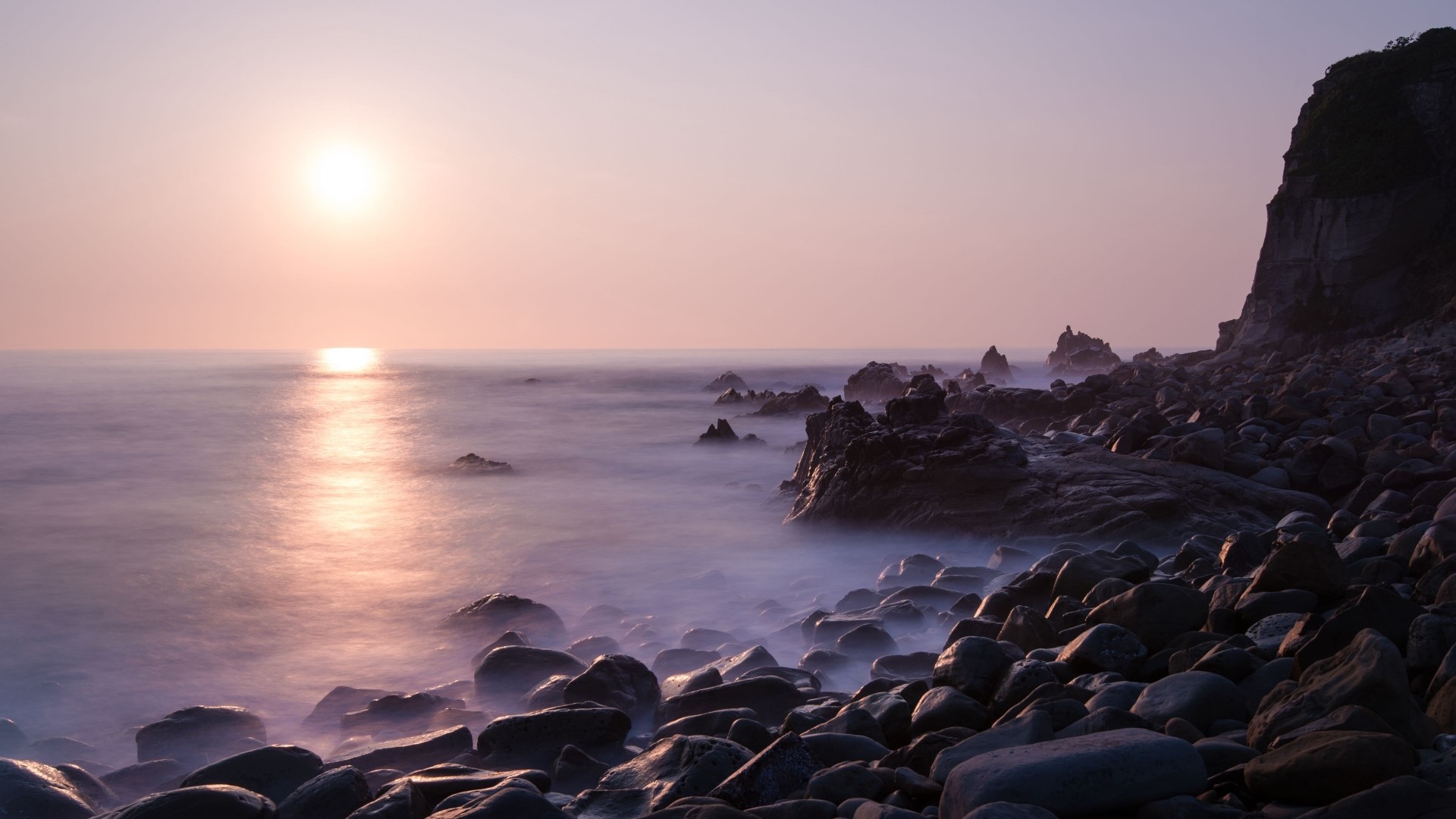 Sunset over rocky shore with ocean waves HD Wallpaper