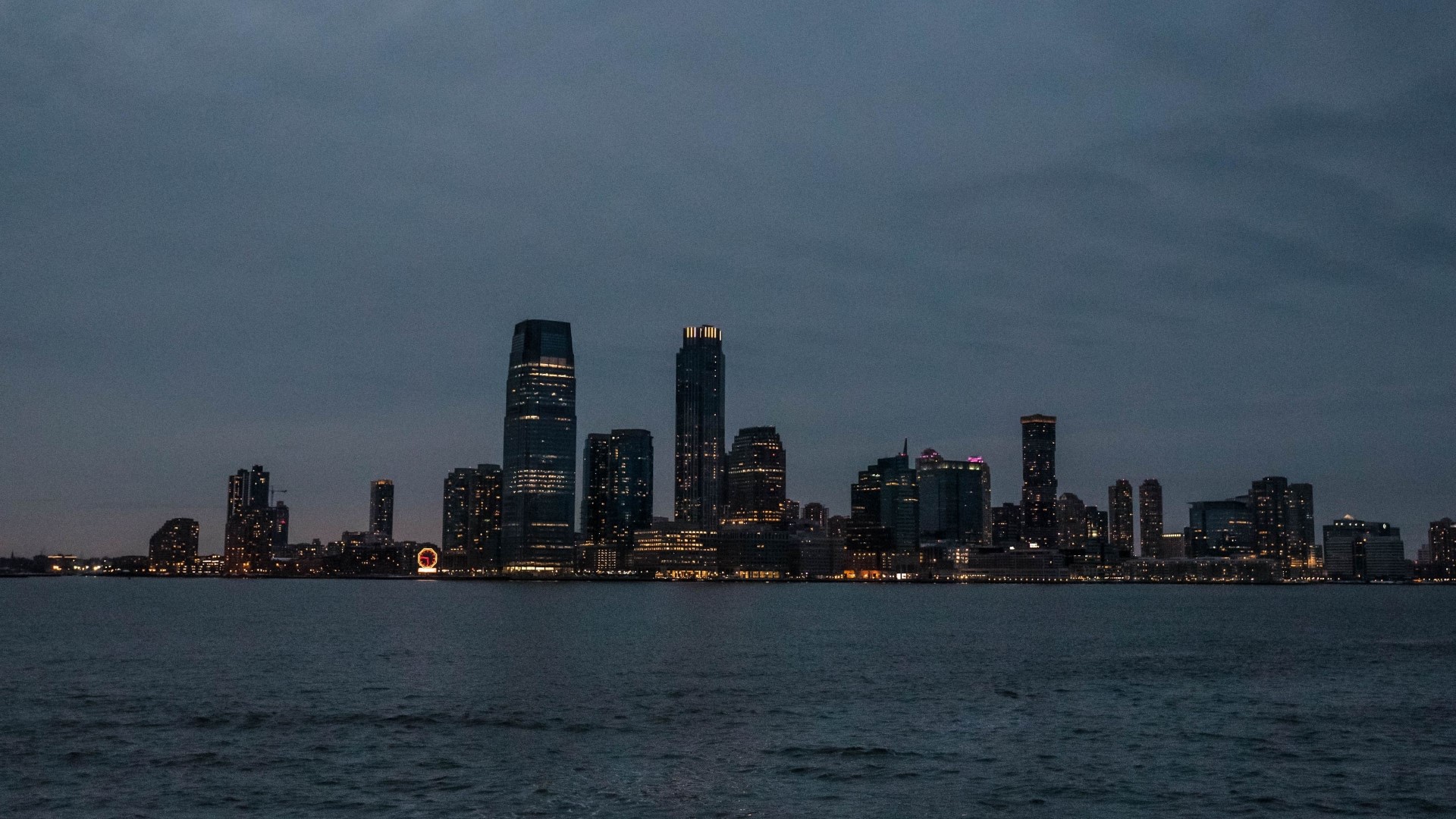 Night skyline of Jersey City with illuminated skyscrapers HD Wallpaper