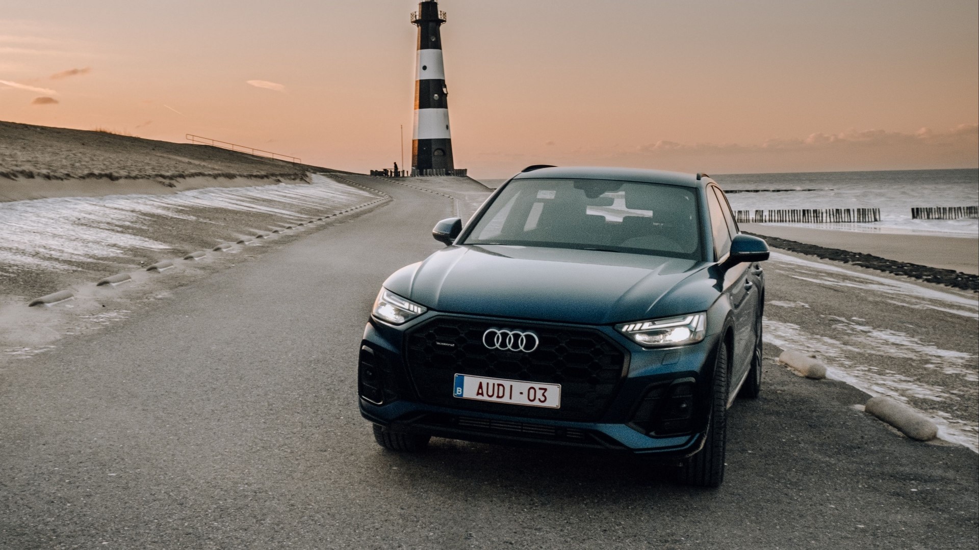 Audi Q5 parked by a lighthouse at sunset HD Wallpaper