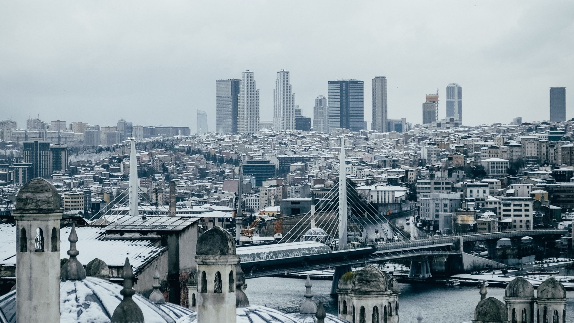 Istanbul cityscape with snow-covered buildings and modern skyscrapers HD Wallpaper