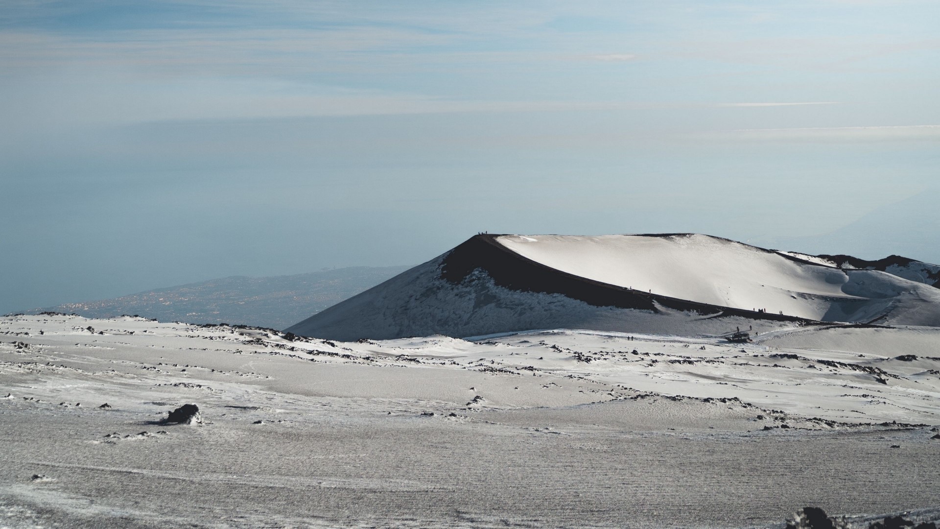 Snow-covered mountain landscape with distant town HD Wallpaper