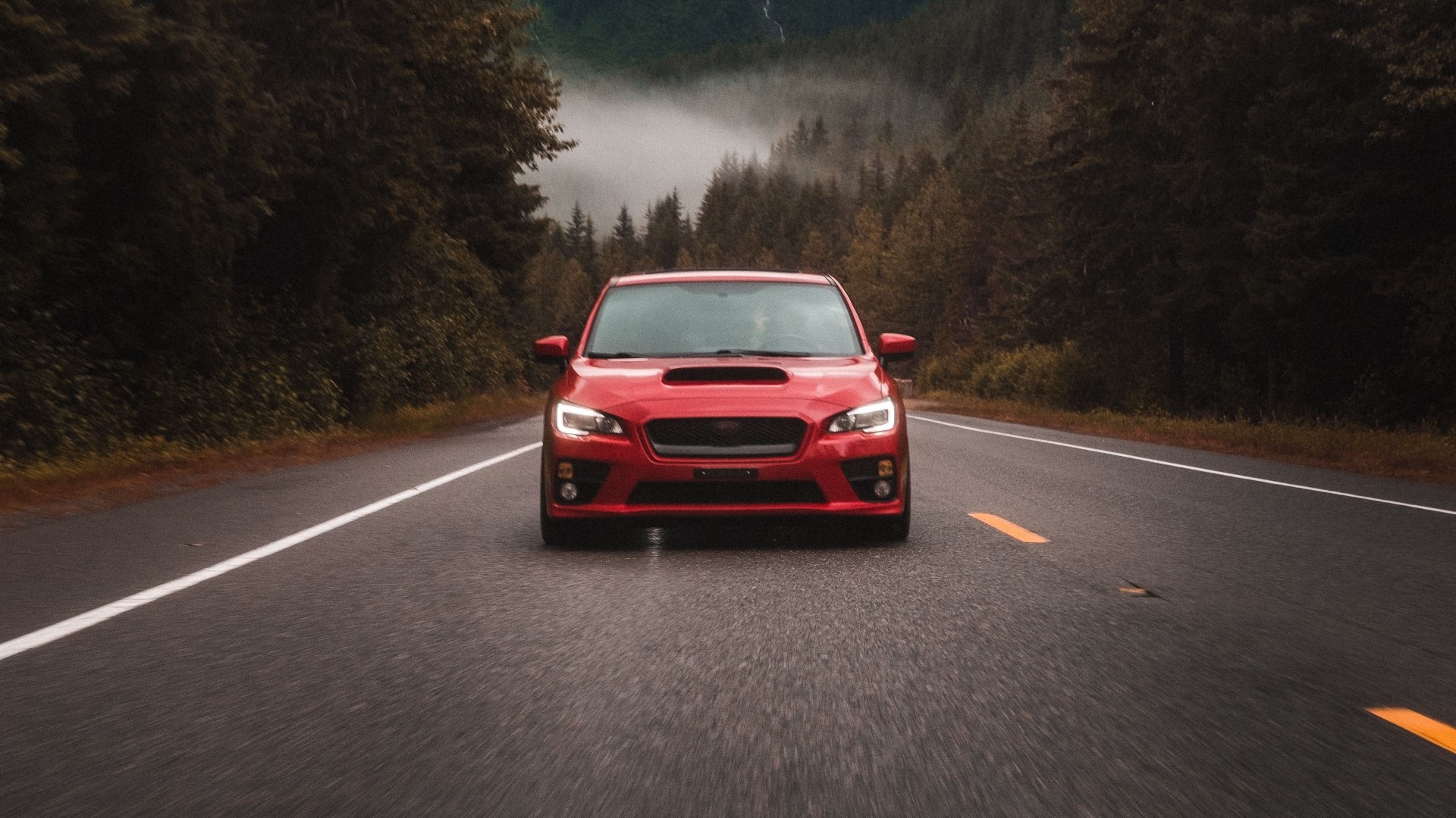 Red Subaru WRX STI driving on a foggy mountain road HD Wallpaper