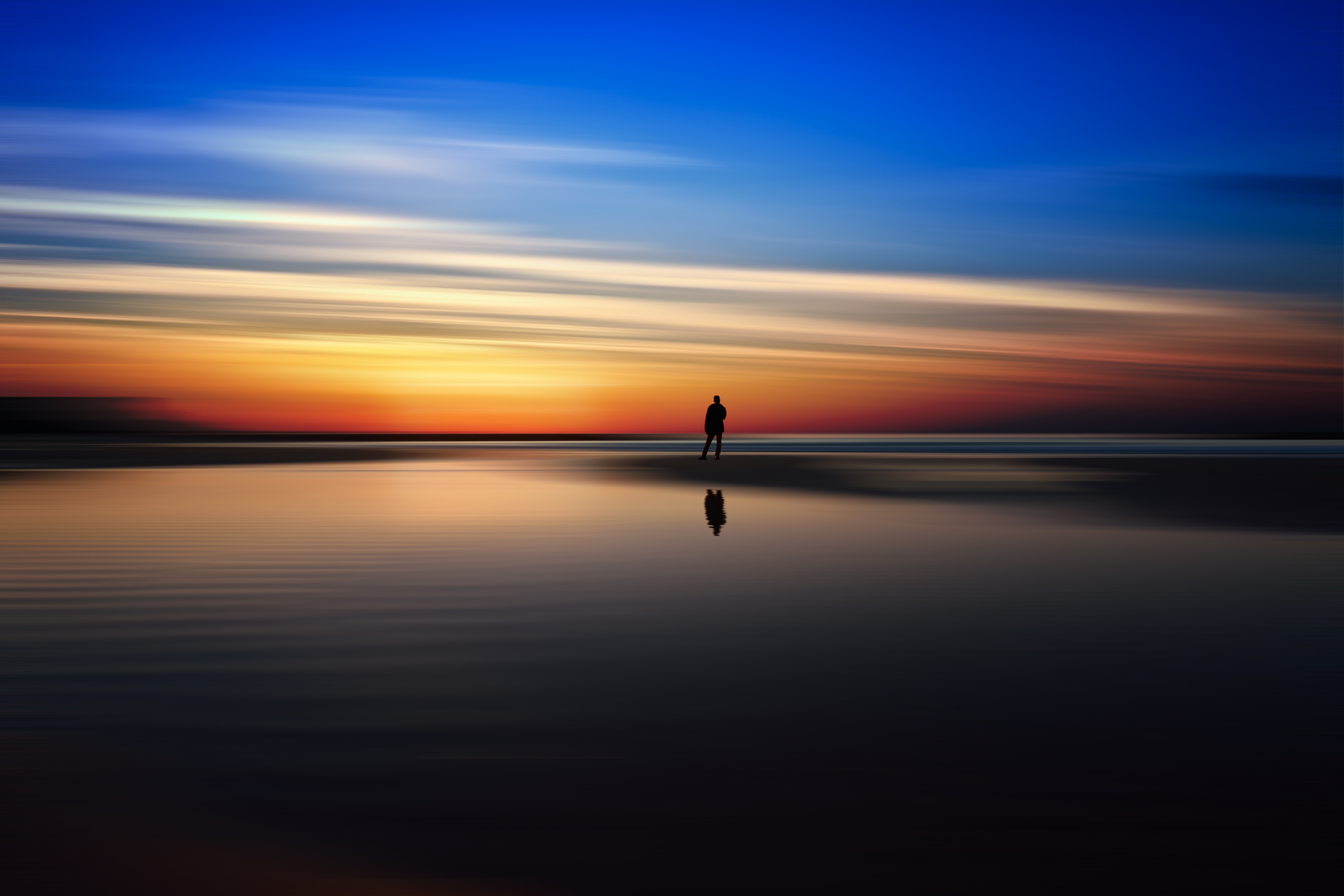 Silhouette of a person on a beach at sunset HD Wallpaper