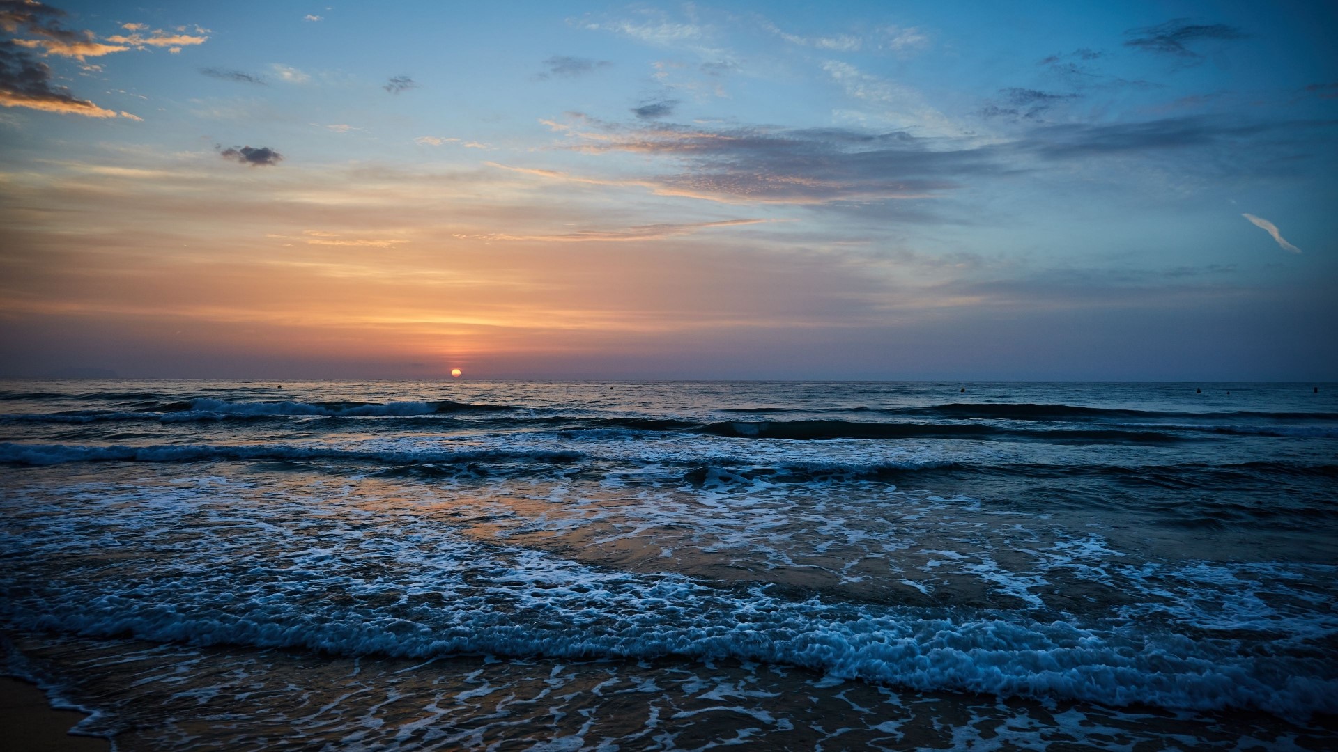 Sunset over the ocean with waves HD Wallpaper