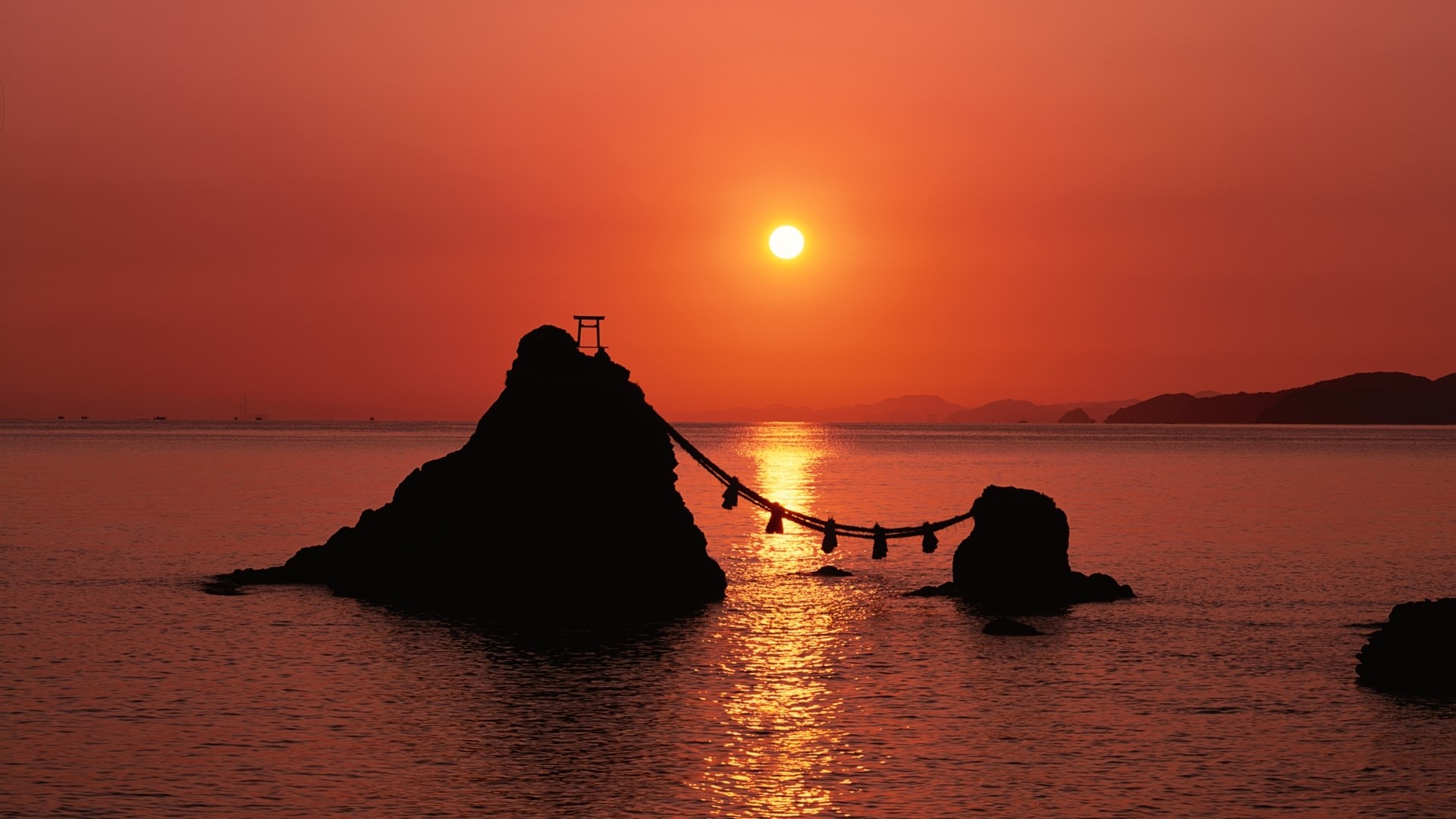 Sunset over the ocean with rocks and a torii gate HD Wallpaper