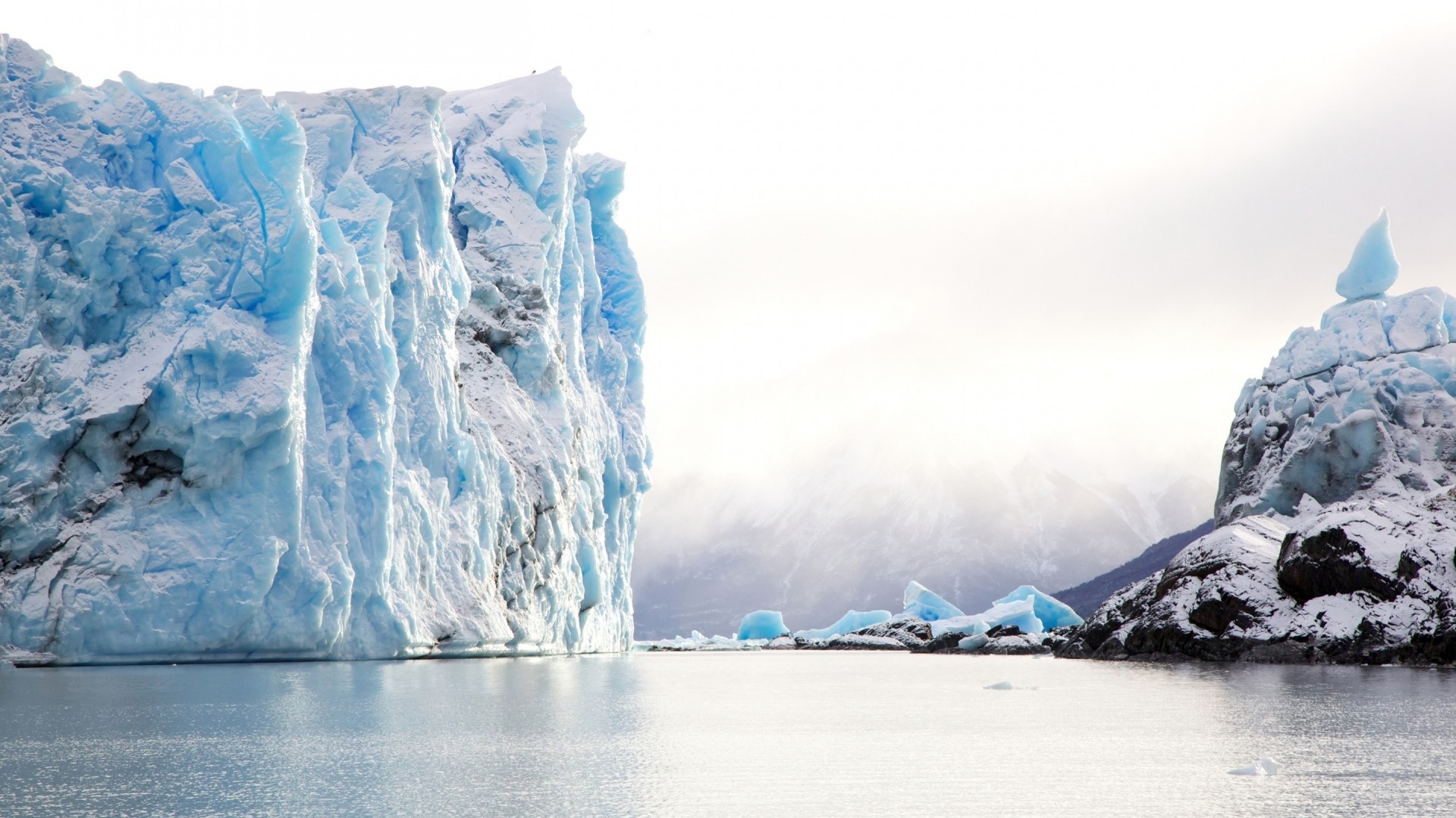 Massive blue iceberg in glacial water HD Wallpaper