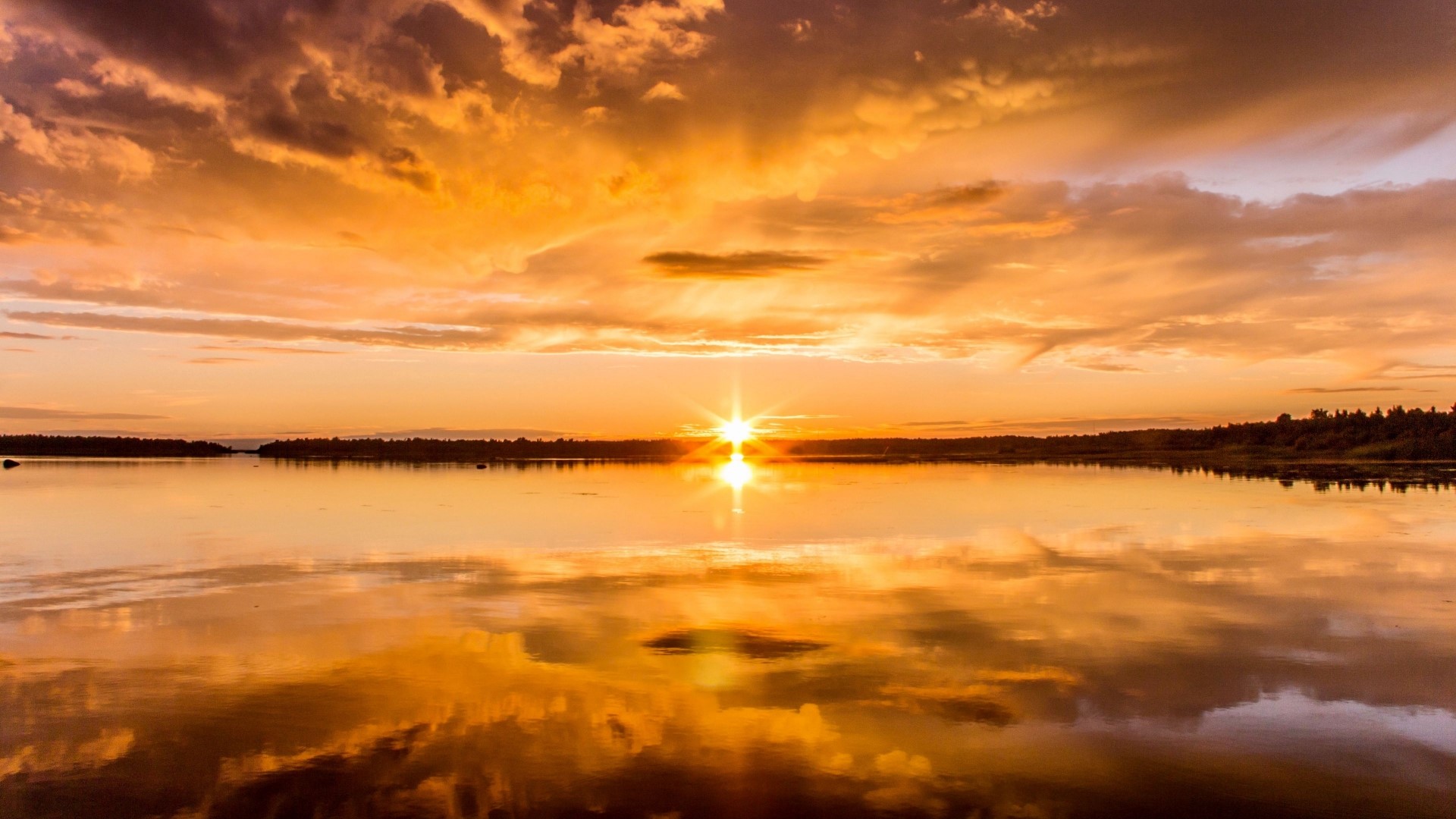 Sunset over a calm lake with dramatic clouds HD Wallpaper