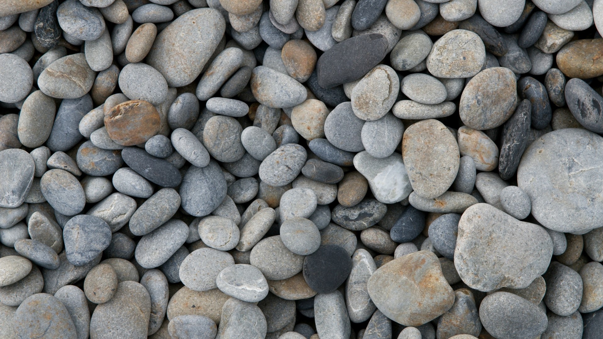 A pile of smooth, rounded stones HD Wallpaper
