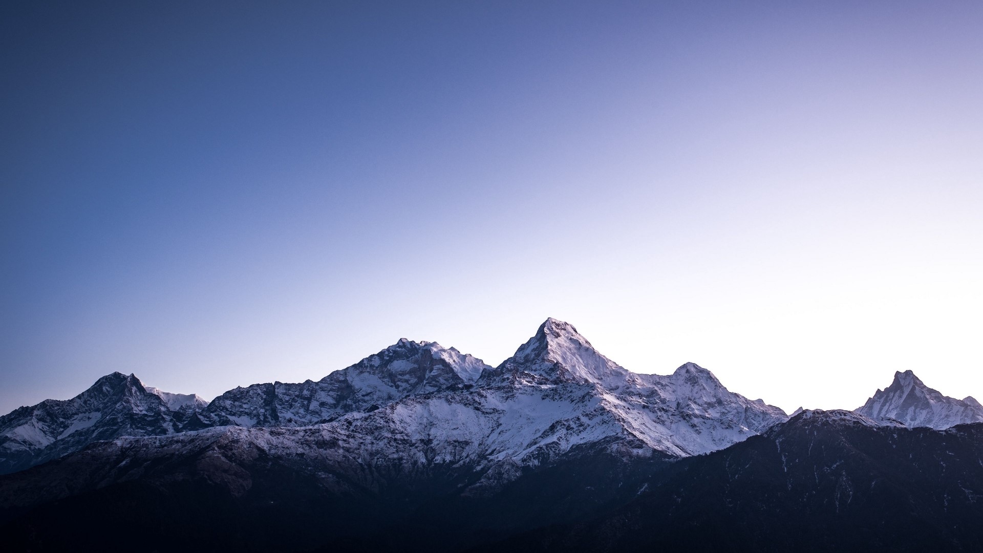 Snow-capped mountains under a clear sky HD Wallpaper