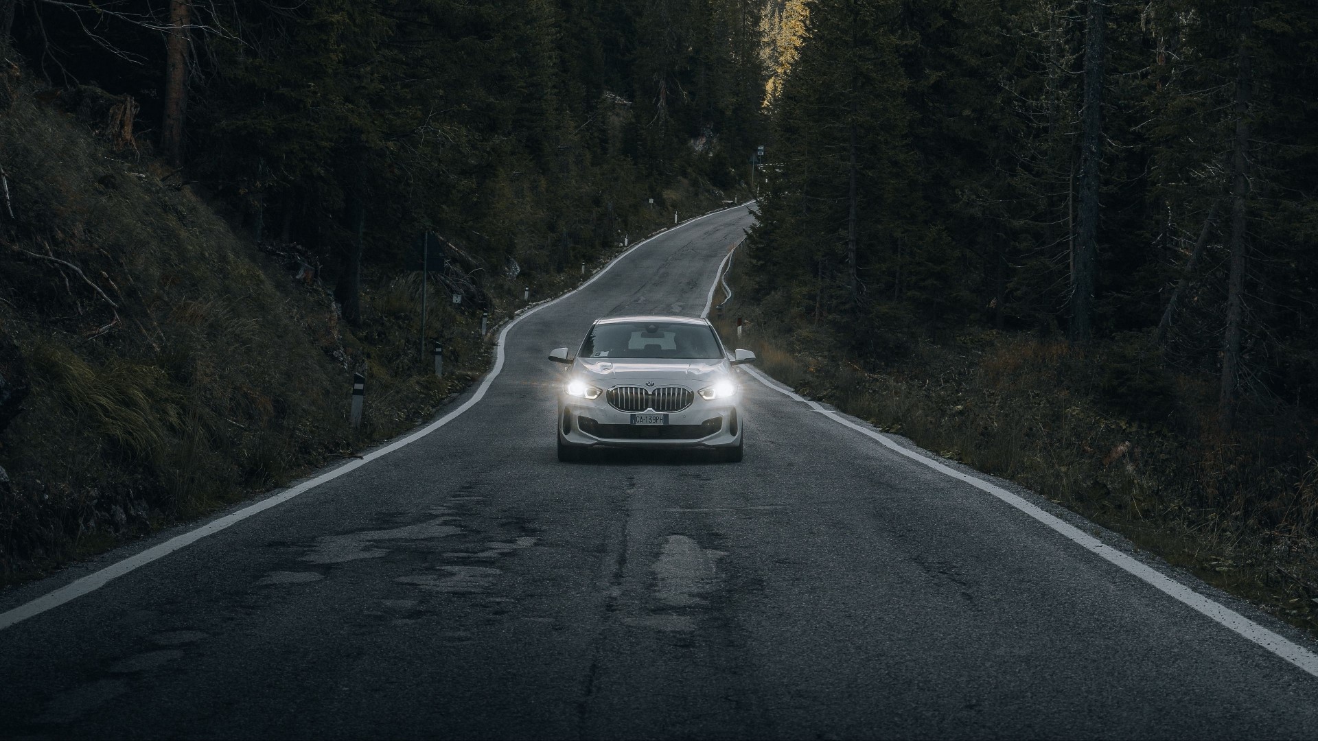 White BMW driving on a winding mountain road HD Wallpaper