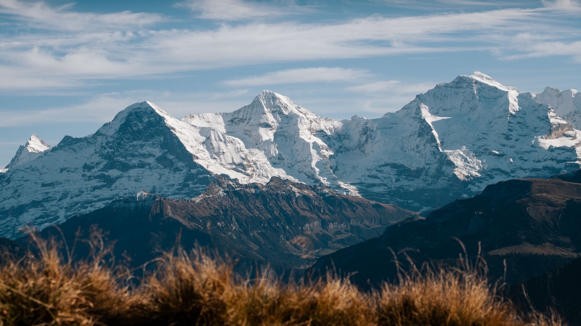 Snow-capped mountains under a blue sky with clouds HD Wallpaper
