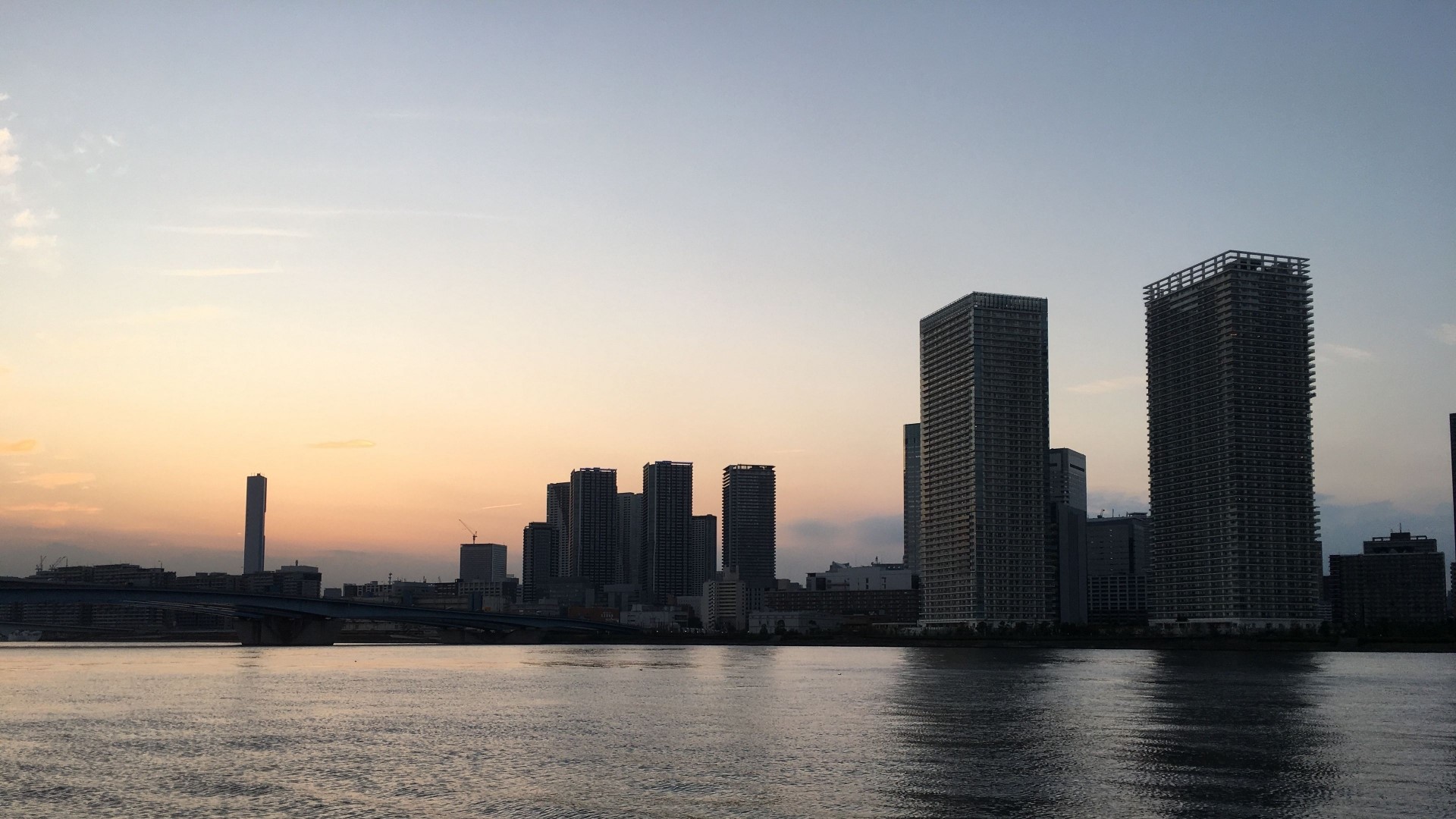 Skyscrapers at sunset over water HD Wallpaper