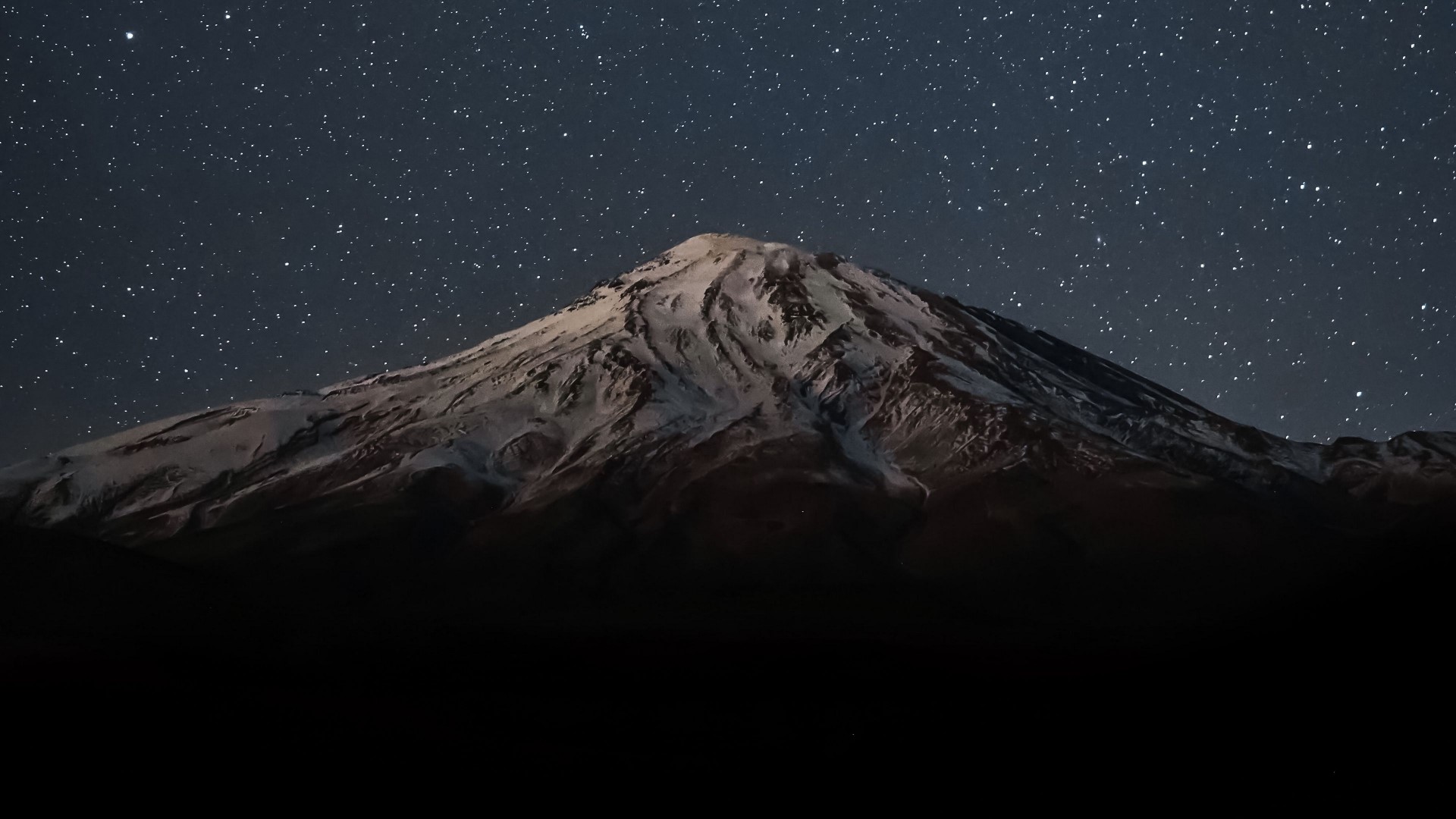 Snow-capped mountain under a starry night sky HD Wallpaper