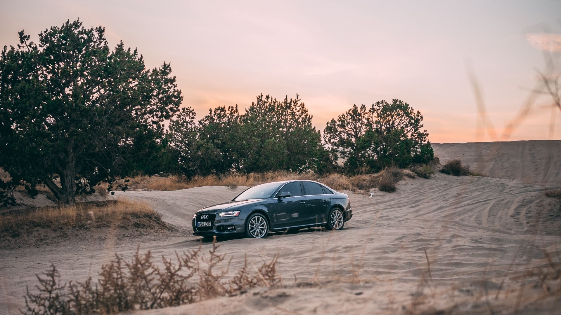 Dark gray Audi sedan on a sandy road HD Wallpaper