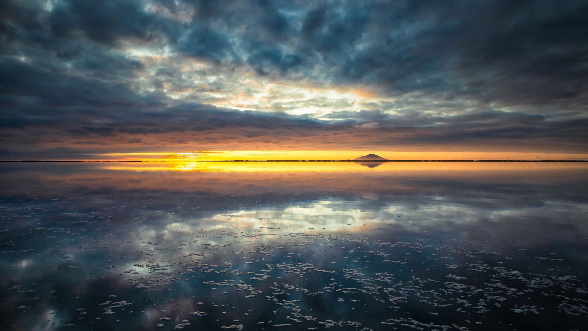 Sunset over a reflective salt flat with clouds HD Wallpaper