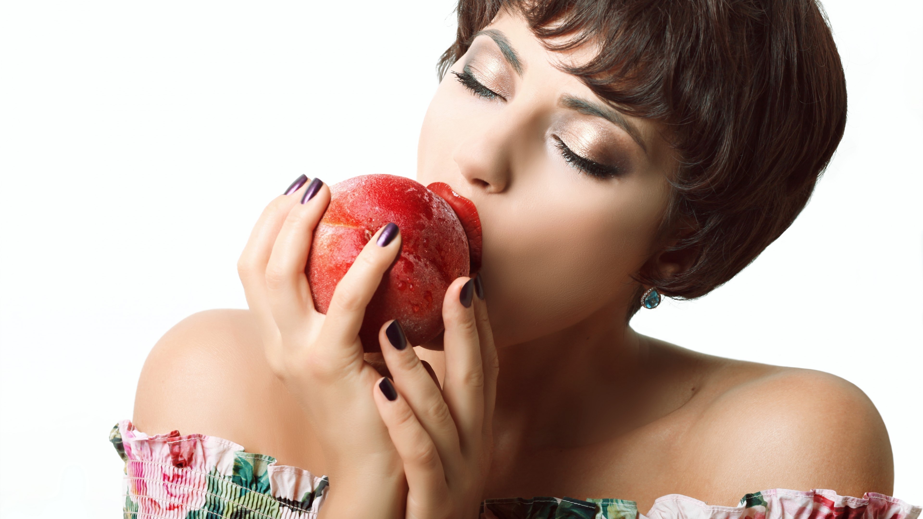 Woman with short hair smelling a peach HD Wallpaper