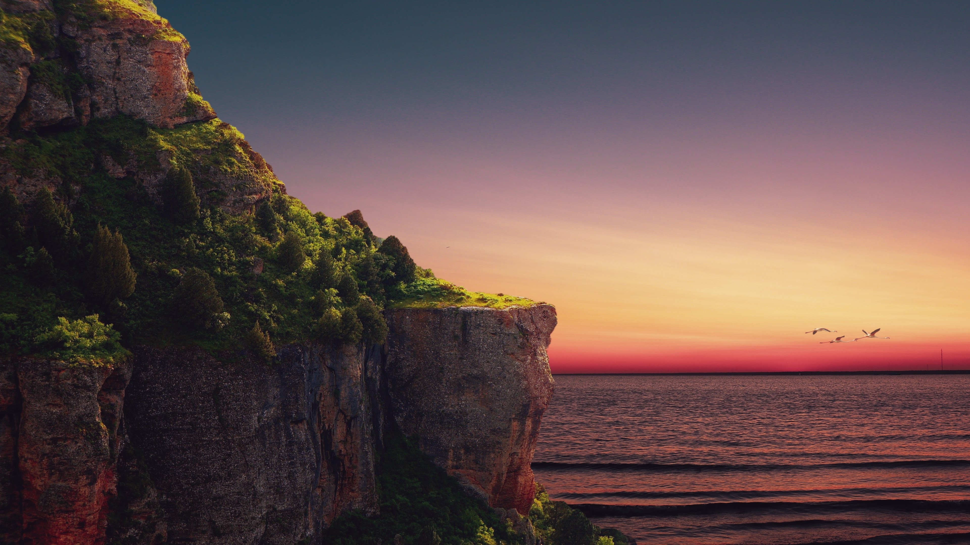 Cliffside overlooking ocean at sunset HD Wallpaper