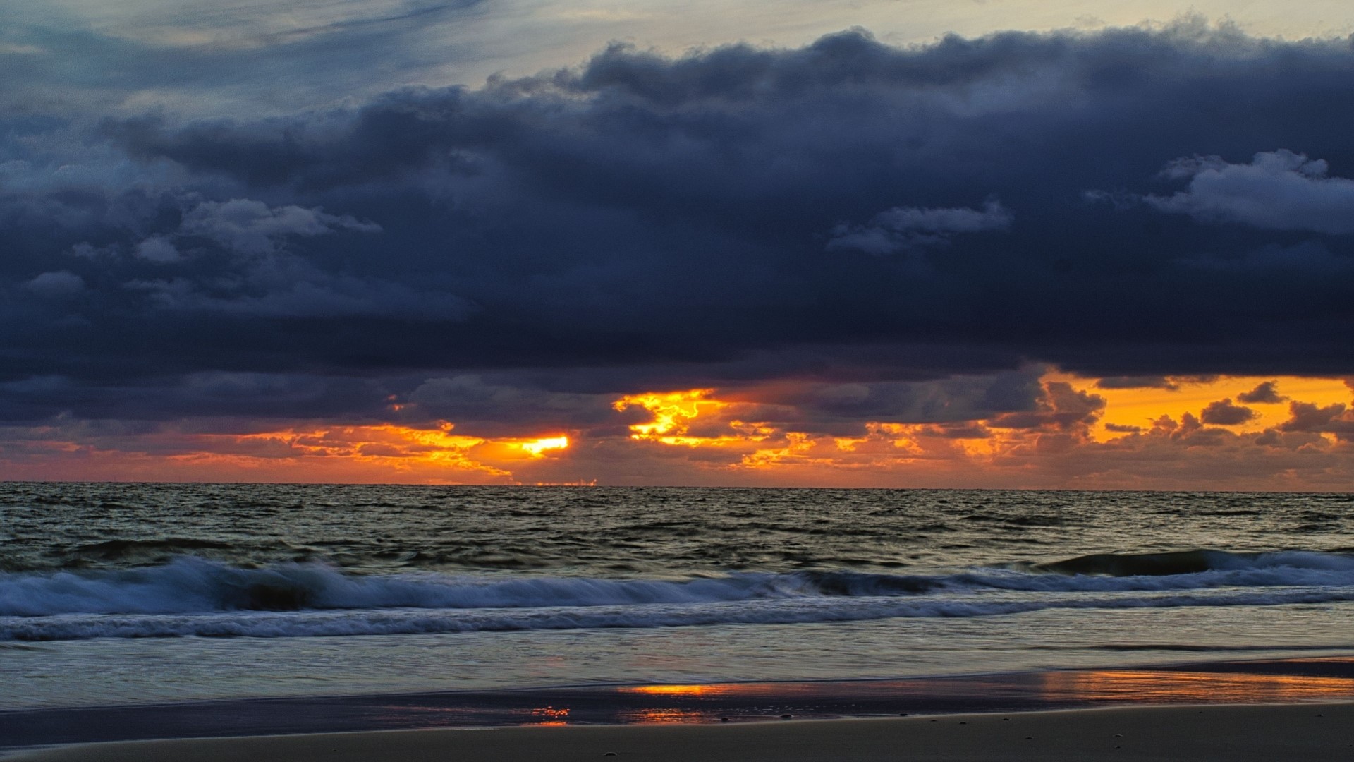 Sunset over the ocean with dark clouds HD Wallpaper