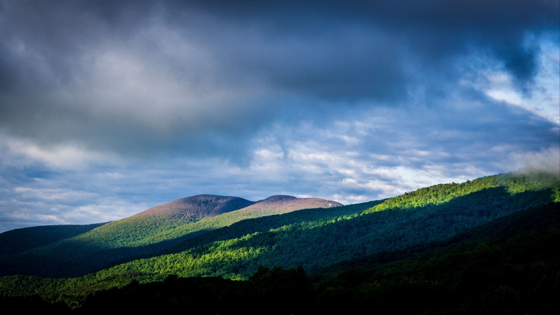 Sunlight on Rolling Hills Under Cloudy Sky HD Wallpaper