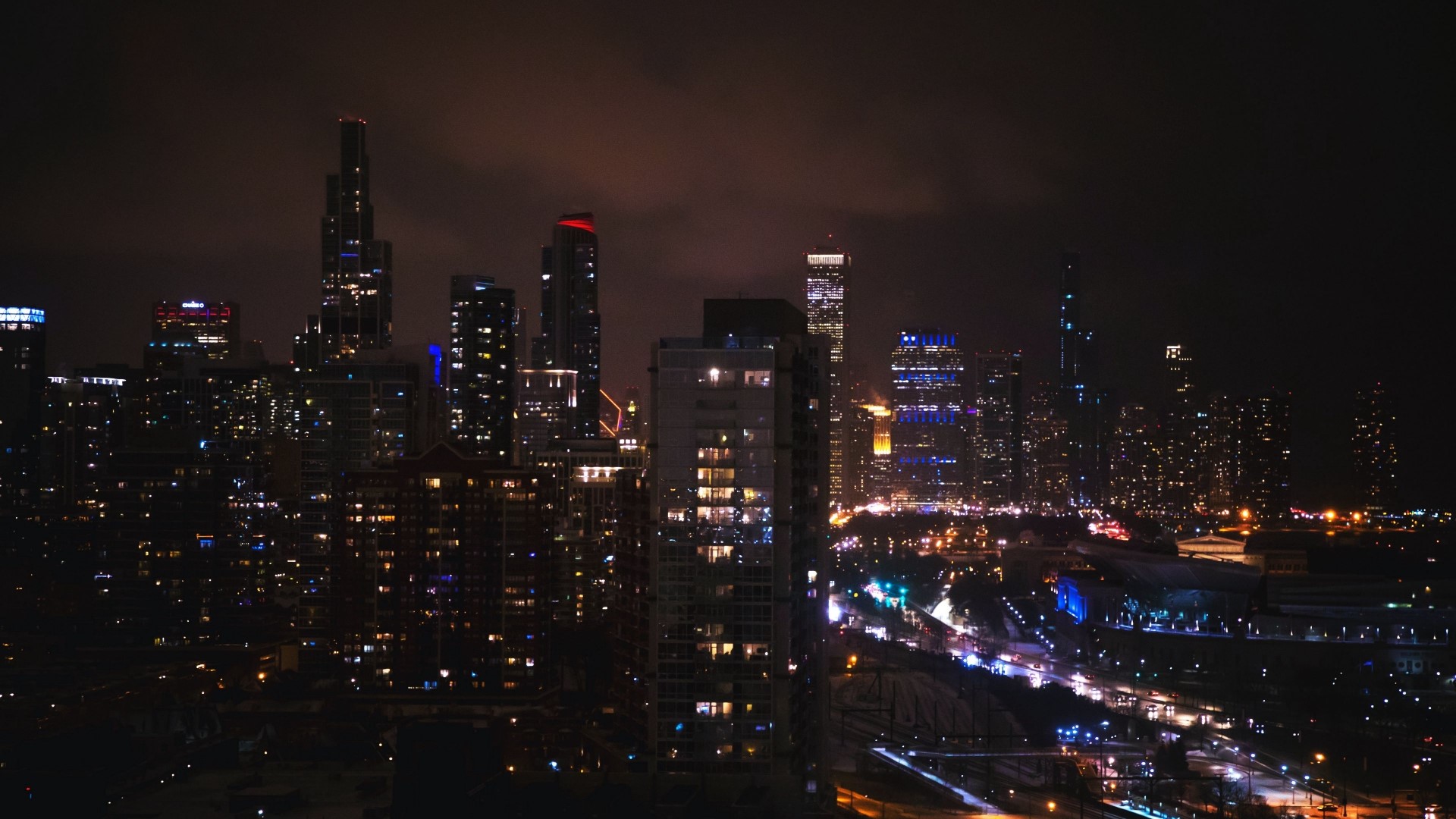 Night cityscape with illuminated skyscrapers and roads HD Wallpaper