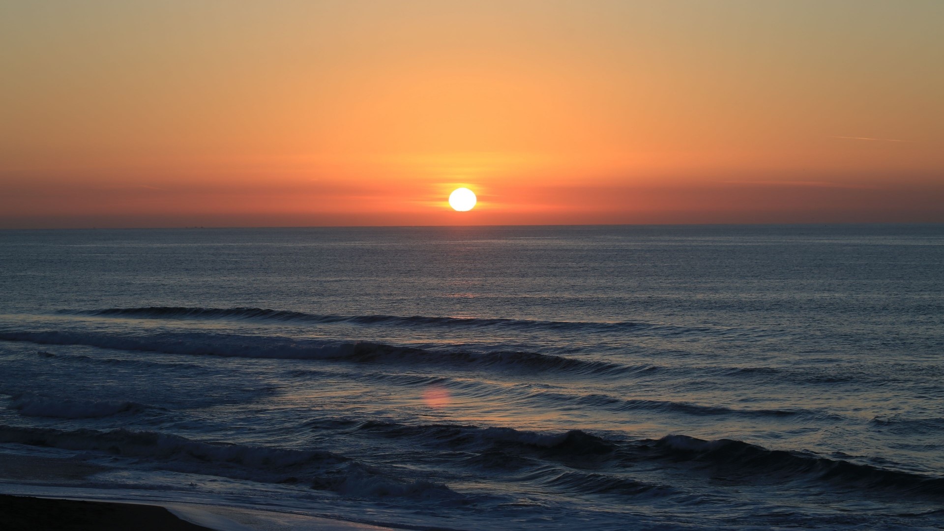 Sunset over the ocean with waves HD Wallpaper