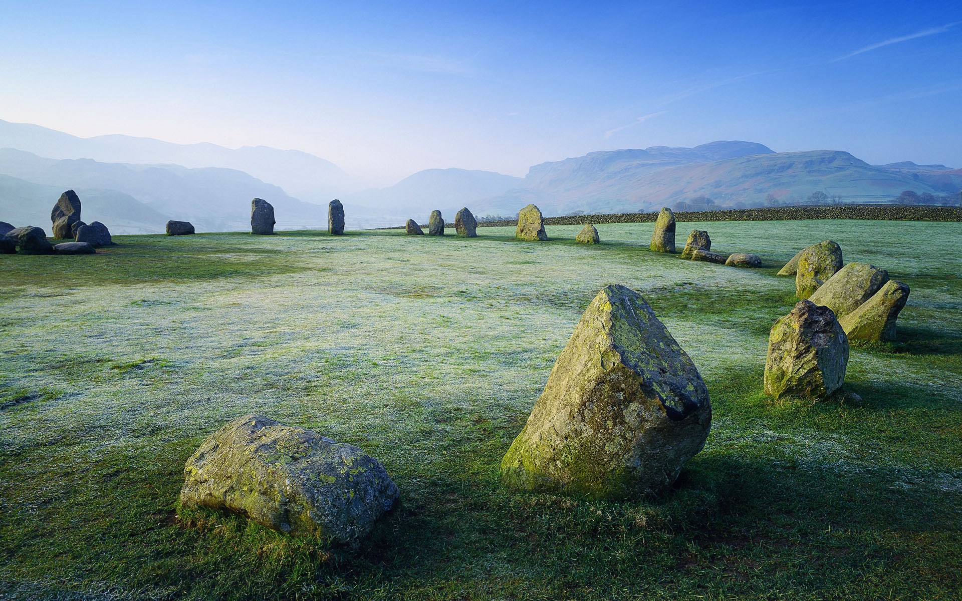 Stone circle in a misty landscape at sunrise HD Wallpaper