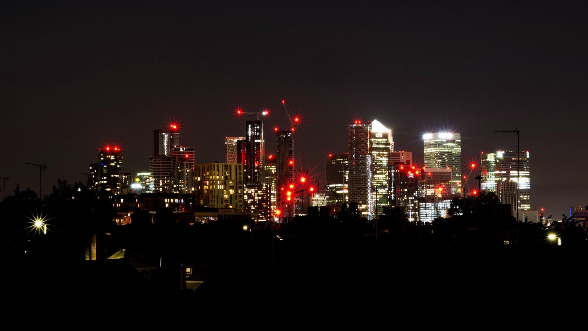 Night cityscape with illuminated skyscrapers and red lights HD Wallpaper