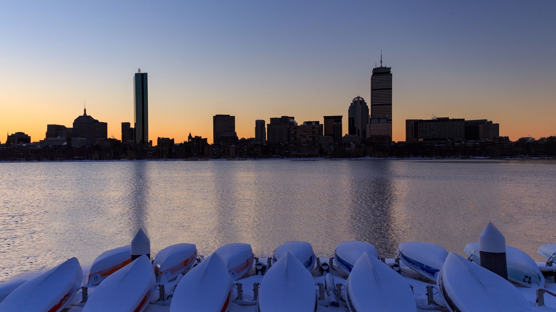 Boston skyline at sunset with boats covered in snow HD Wallpaper