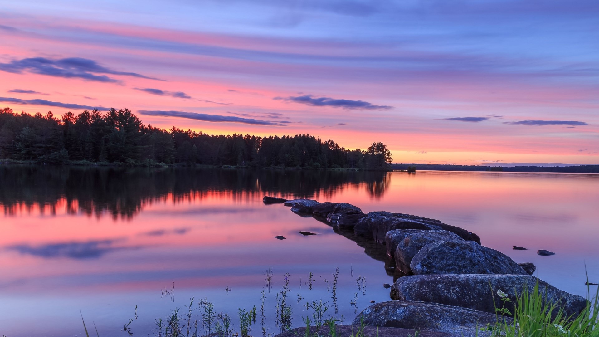 Lake at sunset with colorful sky and rocks HD Wallpaper