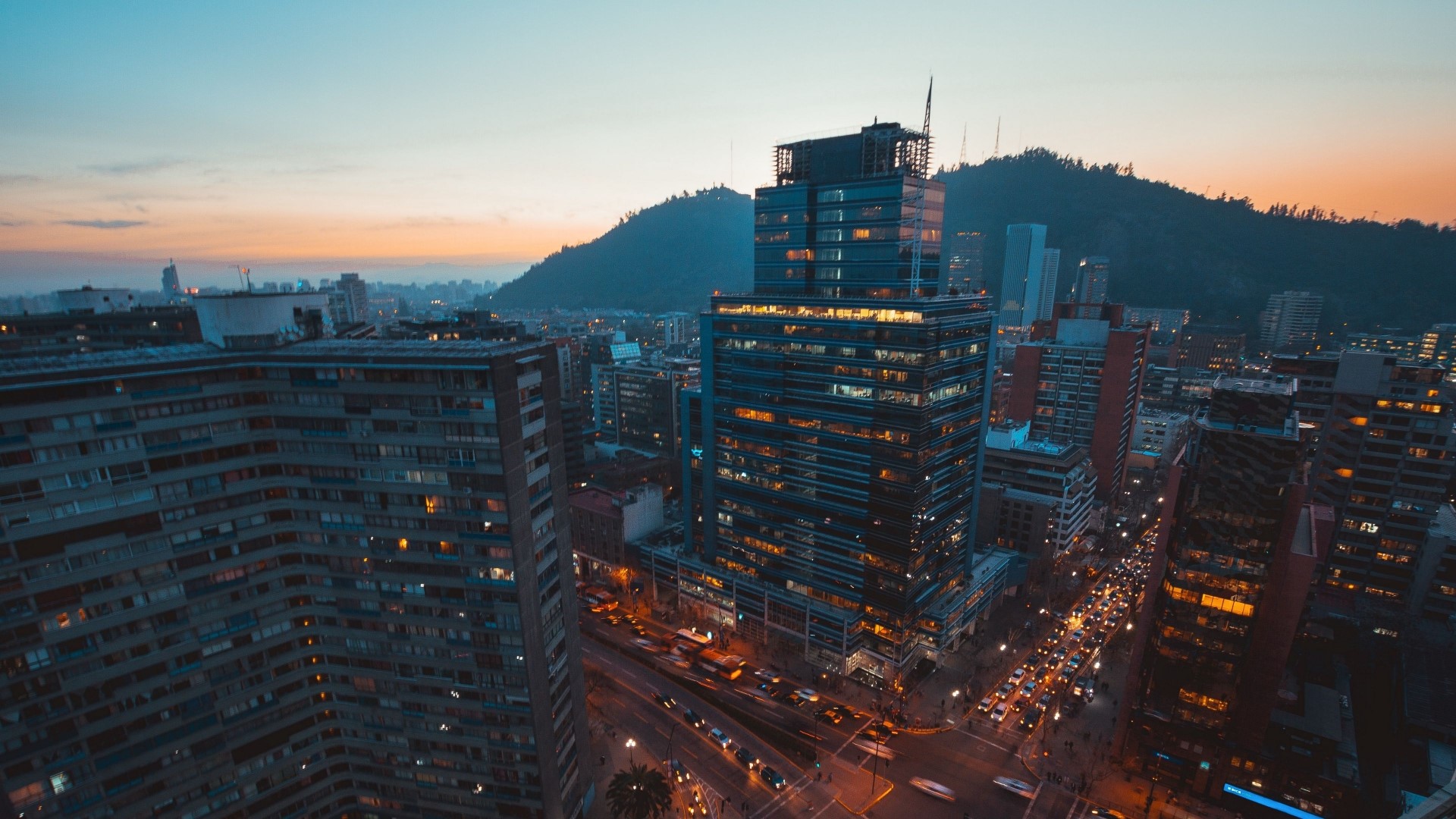 Cityscape at Dusk with Mountains and Traffic HD Wallpaper