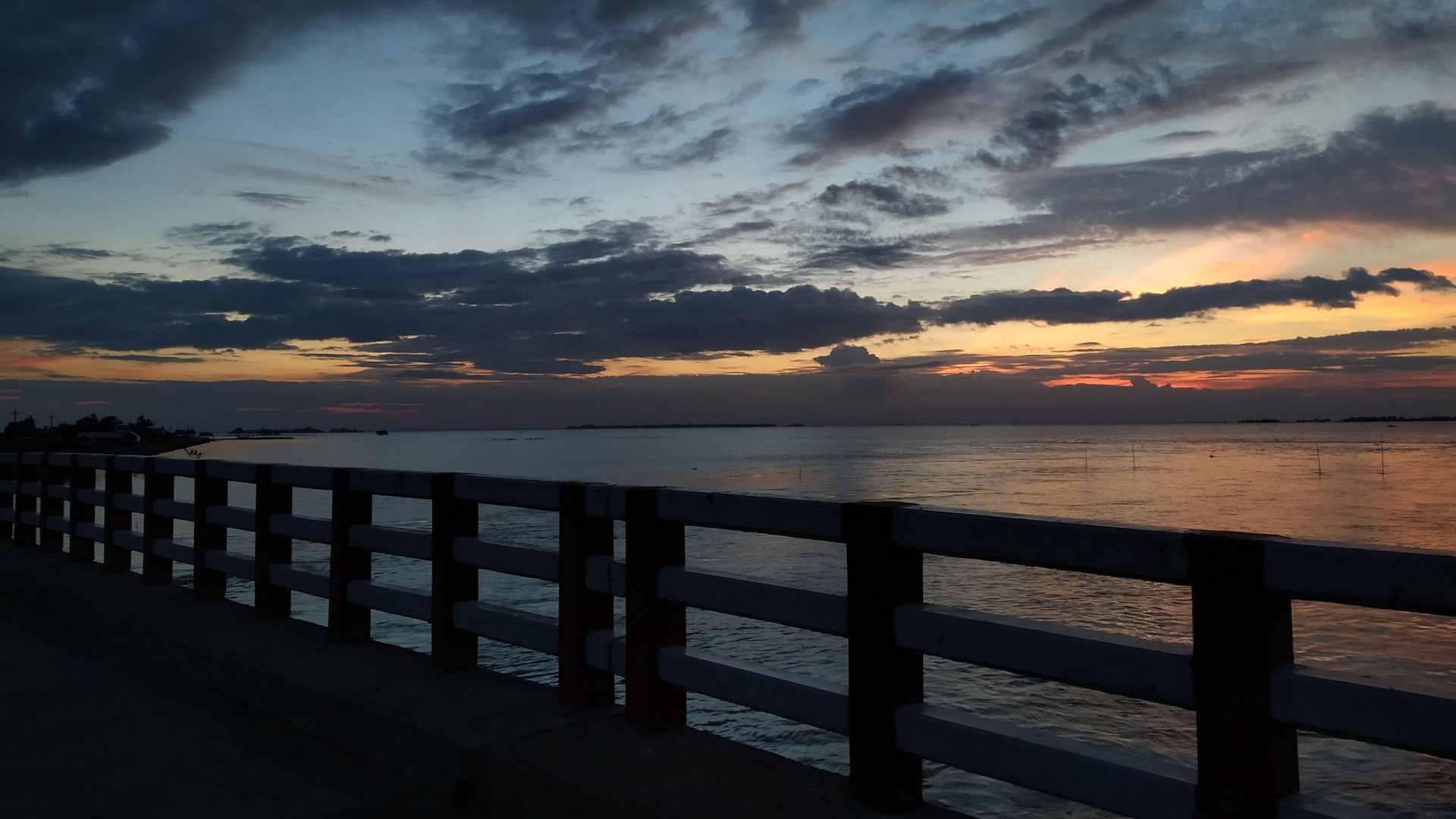 Sunset over the ocean with a bridge railing HD Wallpaper