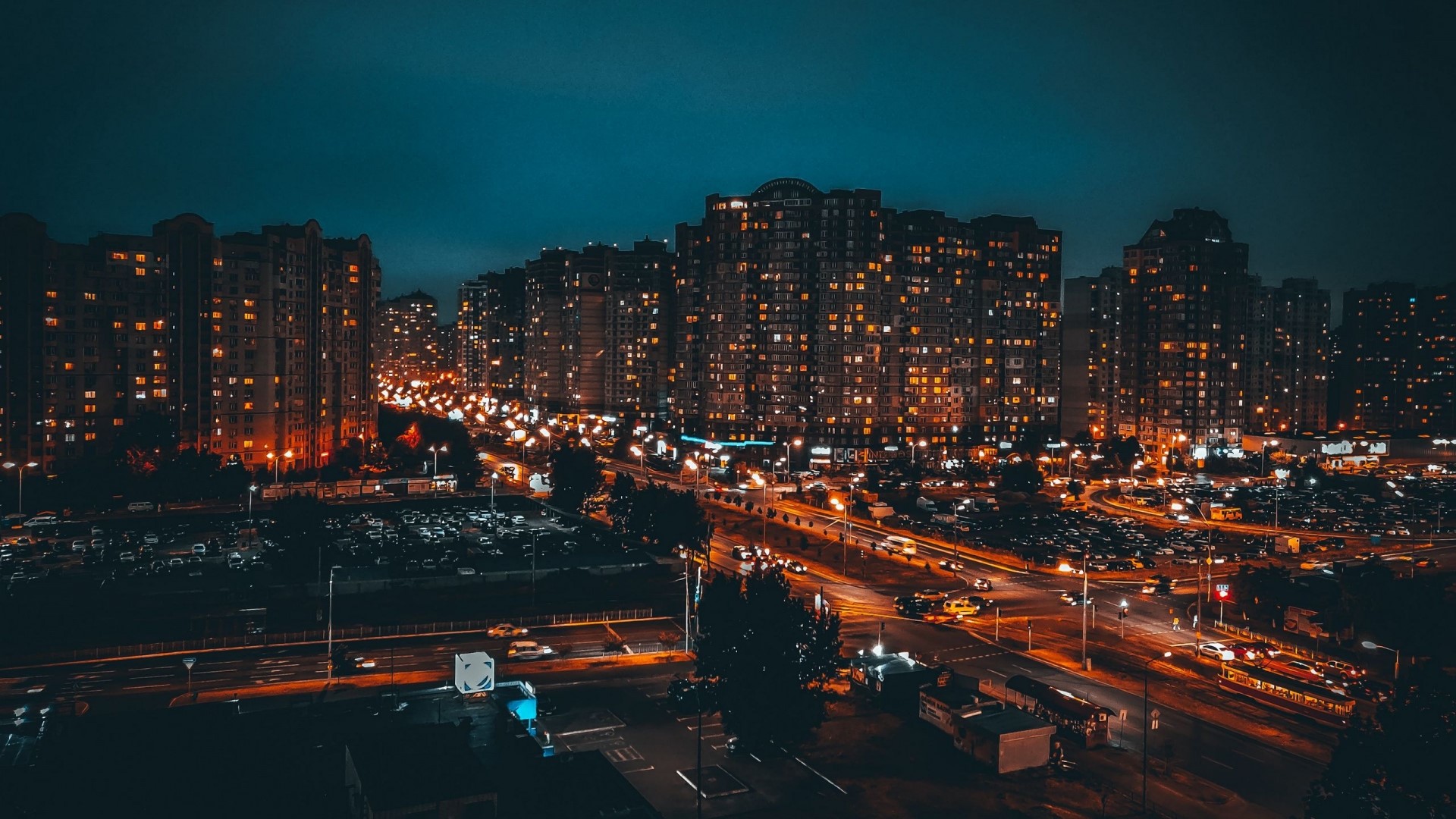 Night city skyline with illuminated buildings and traffic HD Wallpaper