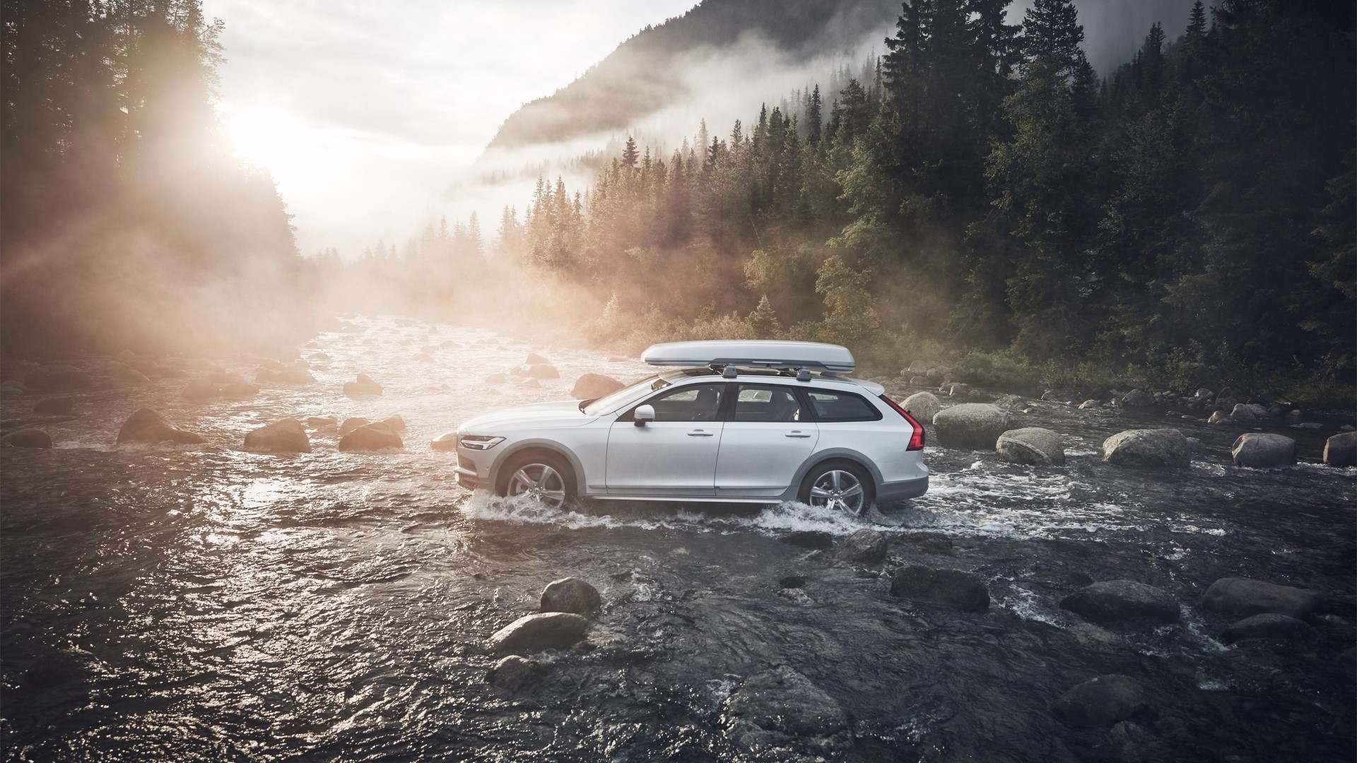 Volvo car driving through a river in a forest HD Wallpaper