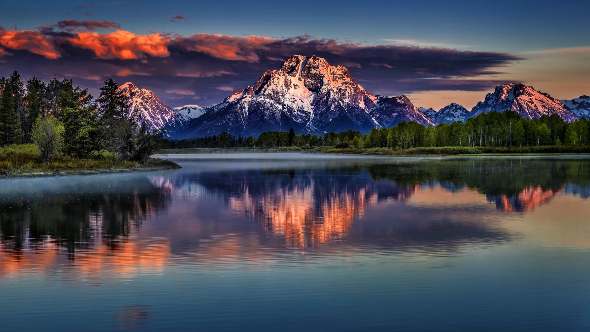Snow-capped mountains reflected in a calm lake at sunset HD Wallpaper