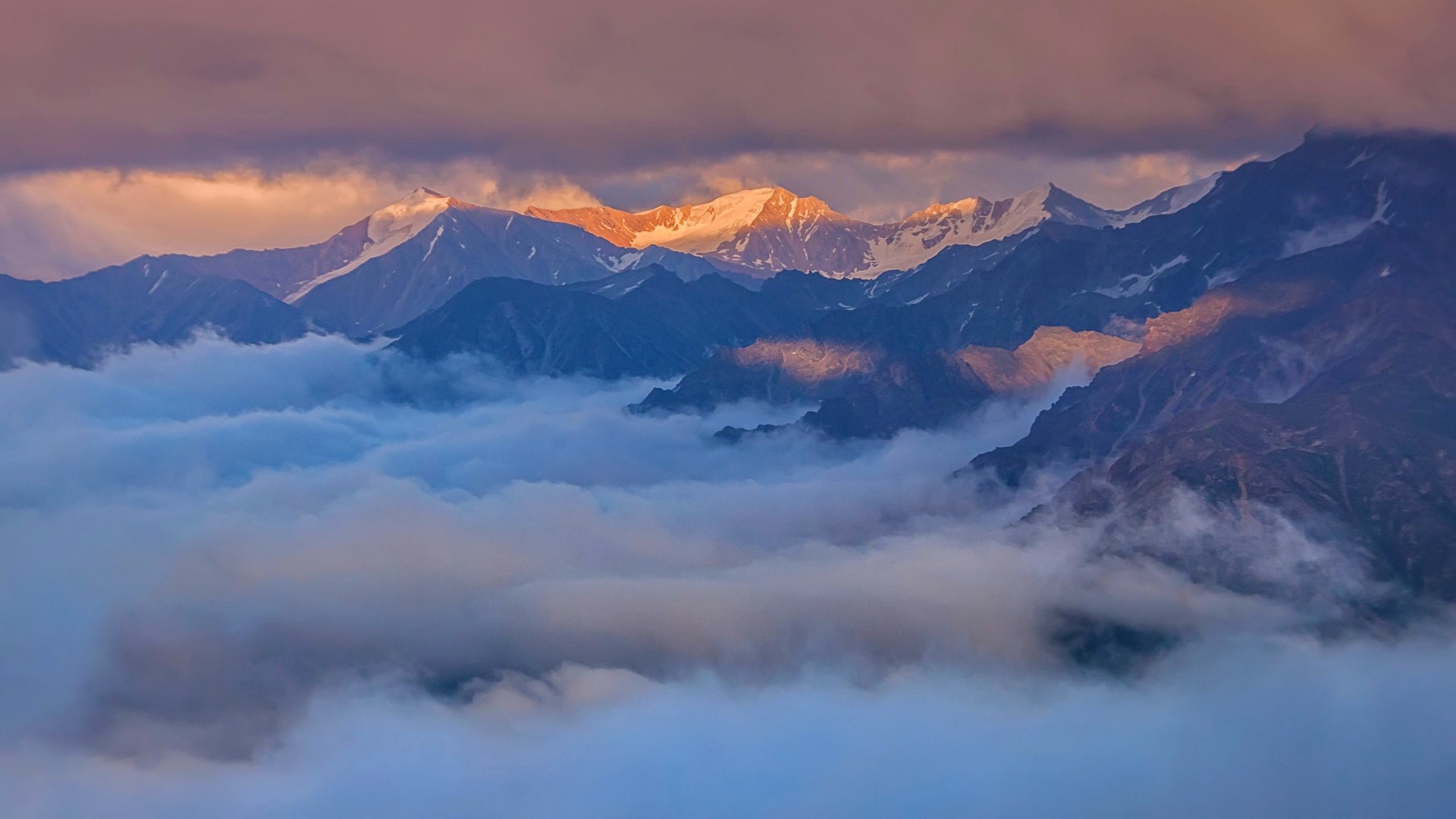 Mountain peaks above clouds at sunset HD Wallpaper