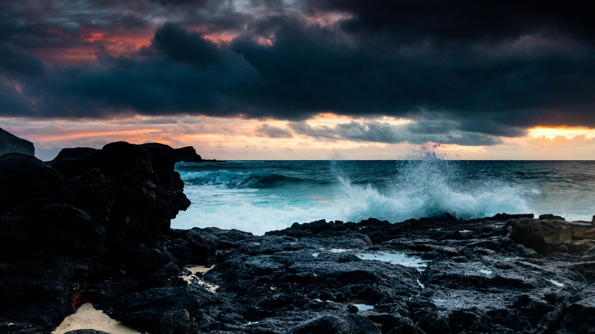 Waves crashing on rocky shore at sunset HD Wallpaper