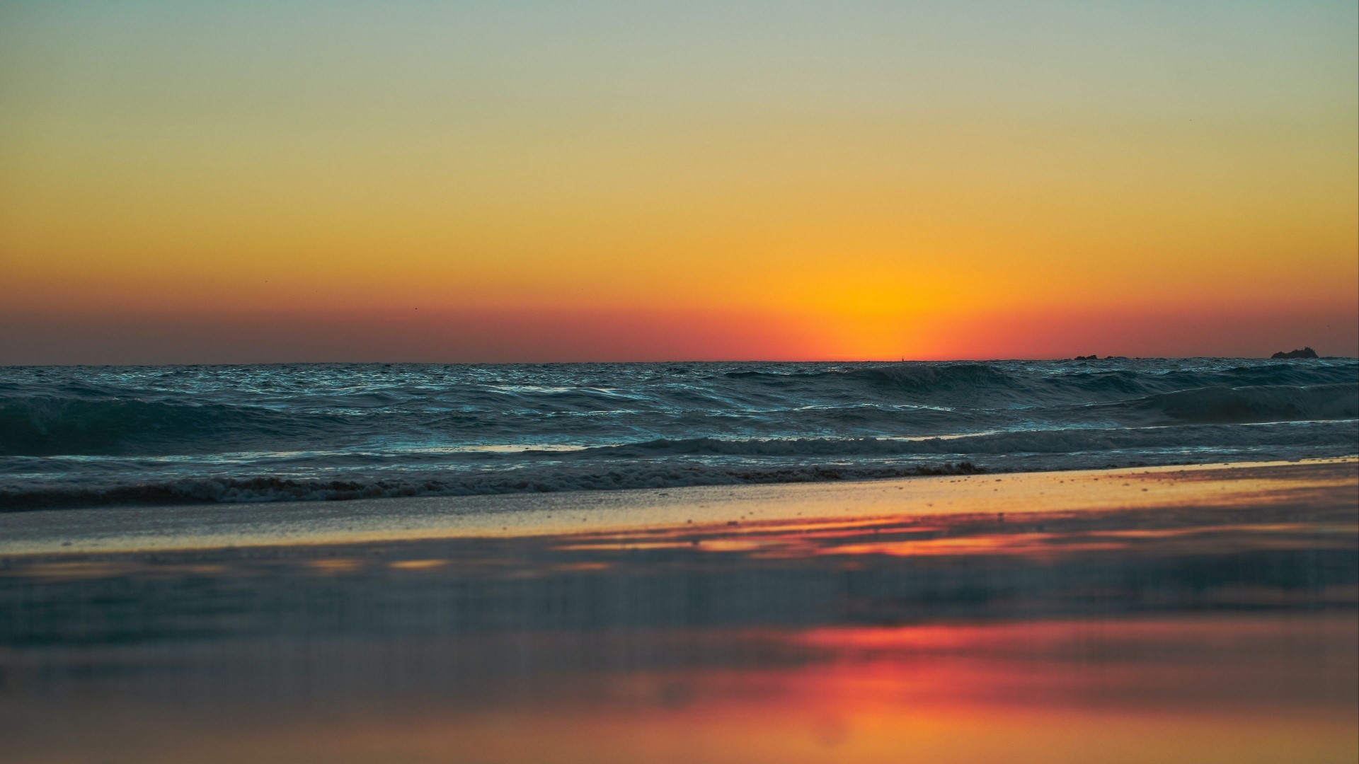 Sunset over the ocean with waves on the beach HD Wallpaper