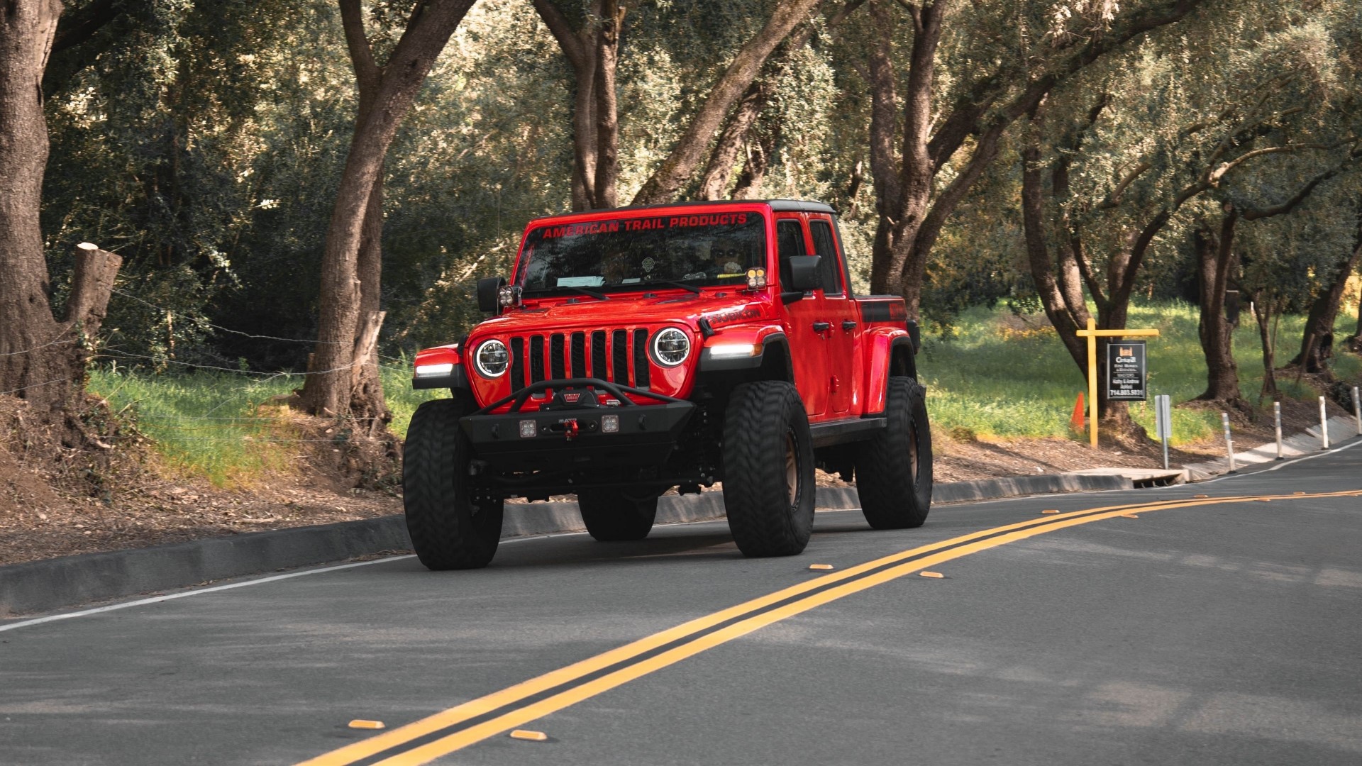 Red Jeep Gladiator driving on a road HD Wallpaper