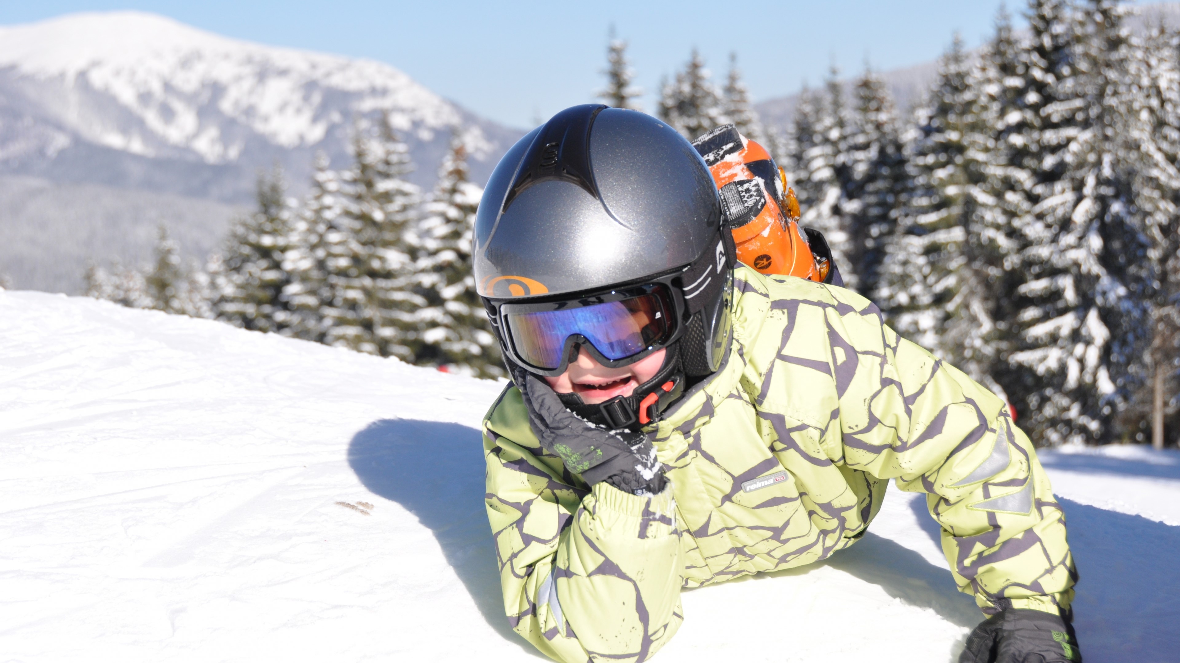 Child in ski gear on snowy mountain HD Wallpaper