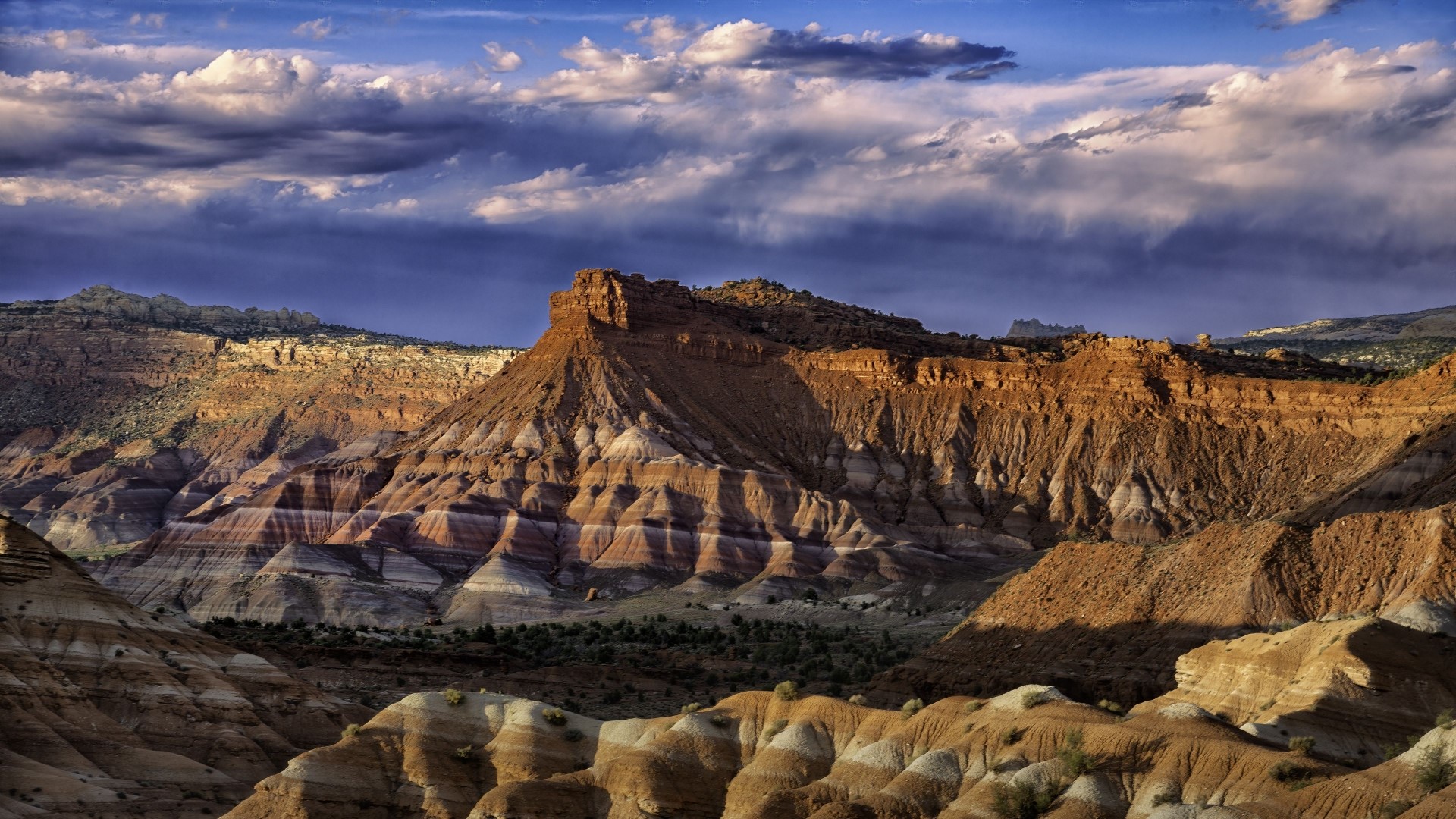 Striped rock formations under a cloudy sky HD Wallpaper