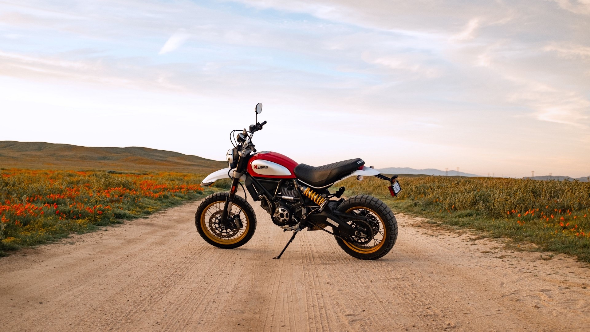 Ducati Scrambler motorcycle on a dirt road HD Wallpaper