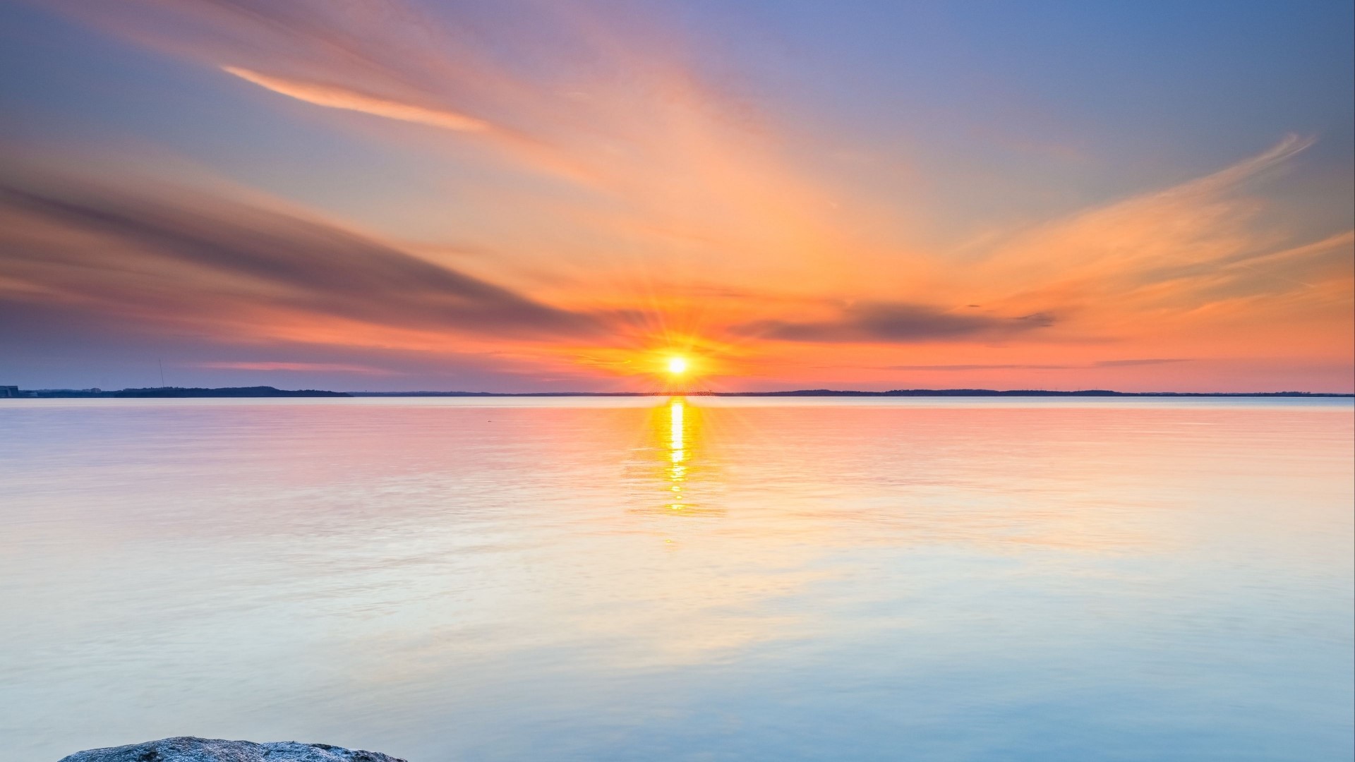 Sunset over a calm body of water with colorful clouds HD Wallpaper