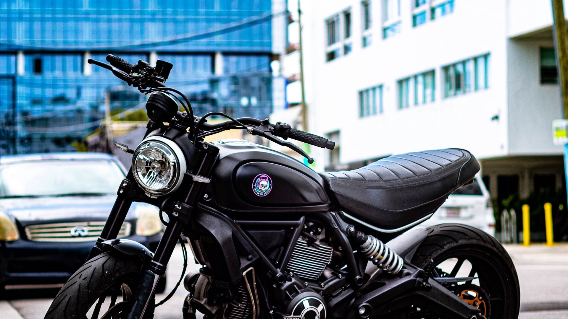 Black motorcycle parked on a city street HD Wallpaper