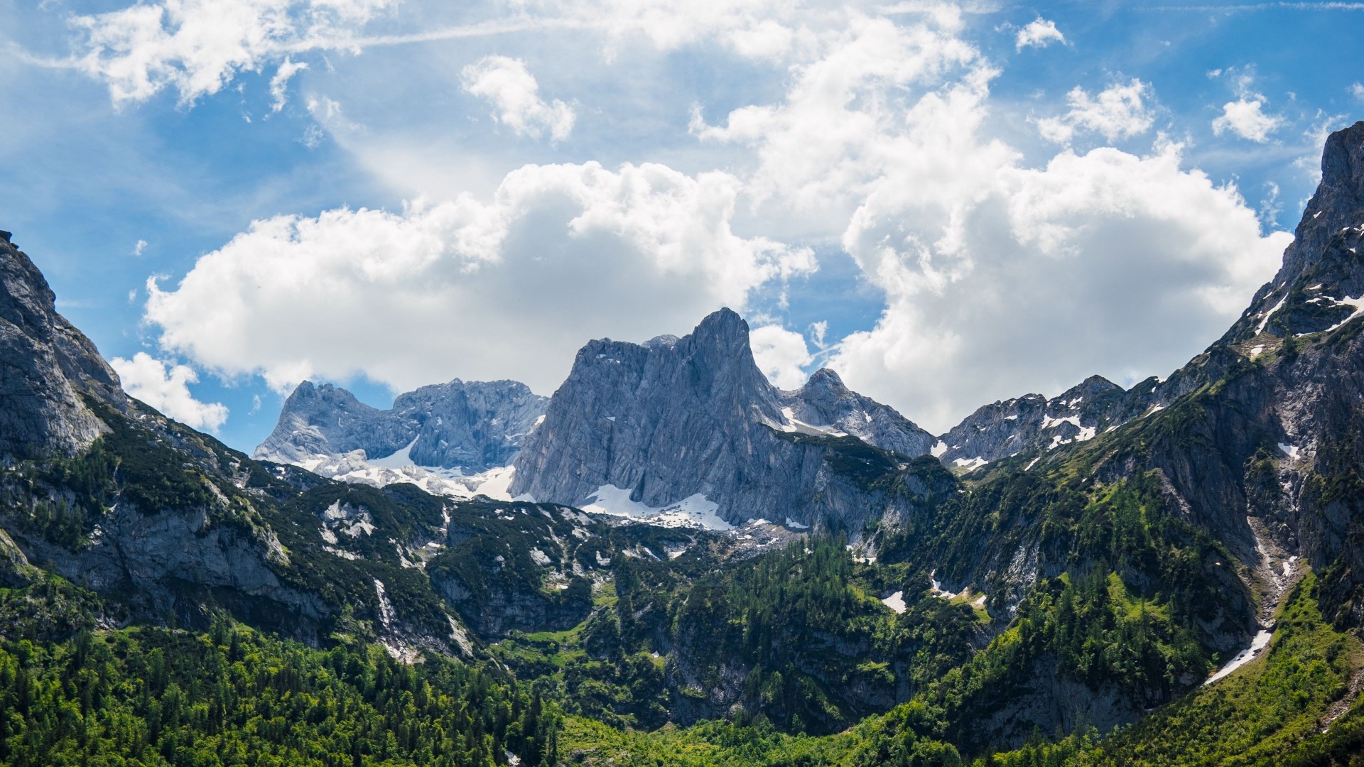 Majestic mountain range under a cloudy sky HD Wallpaper